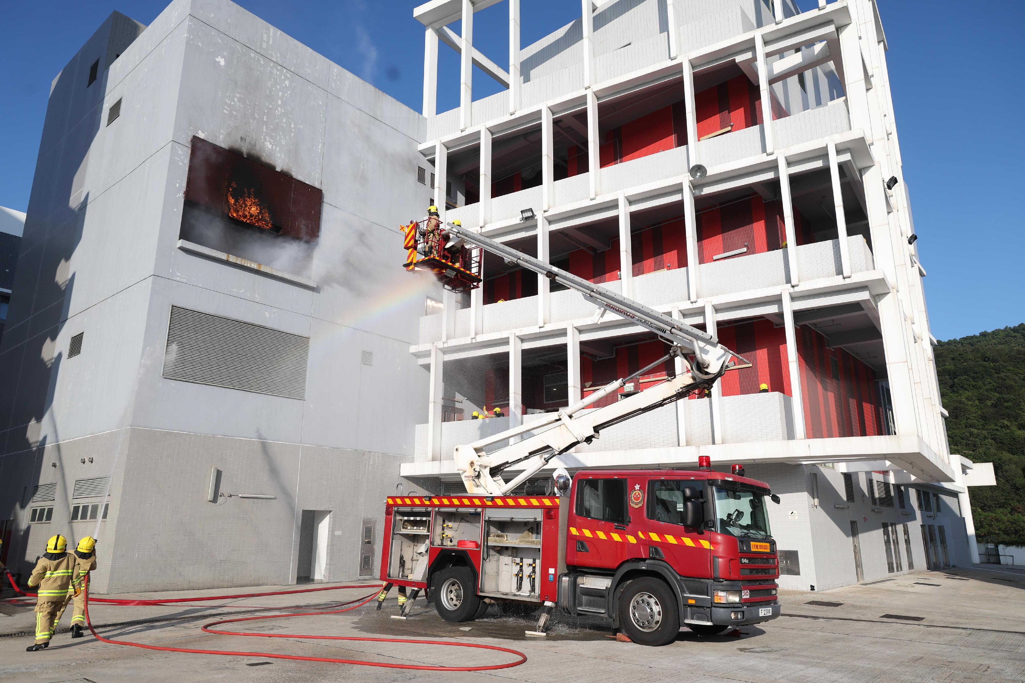 The Secretary for Housing, Ms Winnie Ho, reviewed the Fire Services passing-out parade at the Fire and Ambulance Services Academy today (November 22). Photo shows graduates demonstrating firefighting techniques.