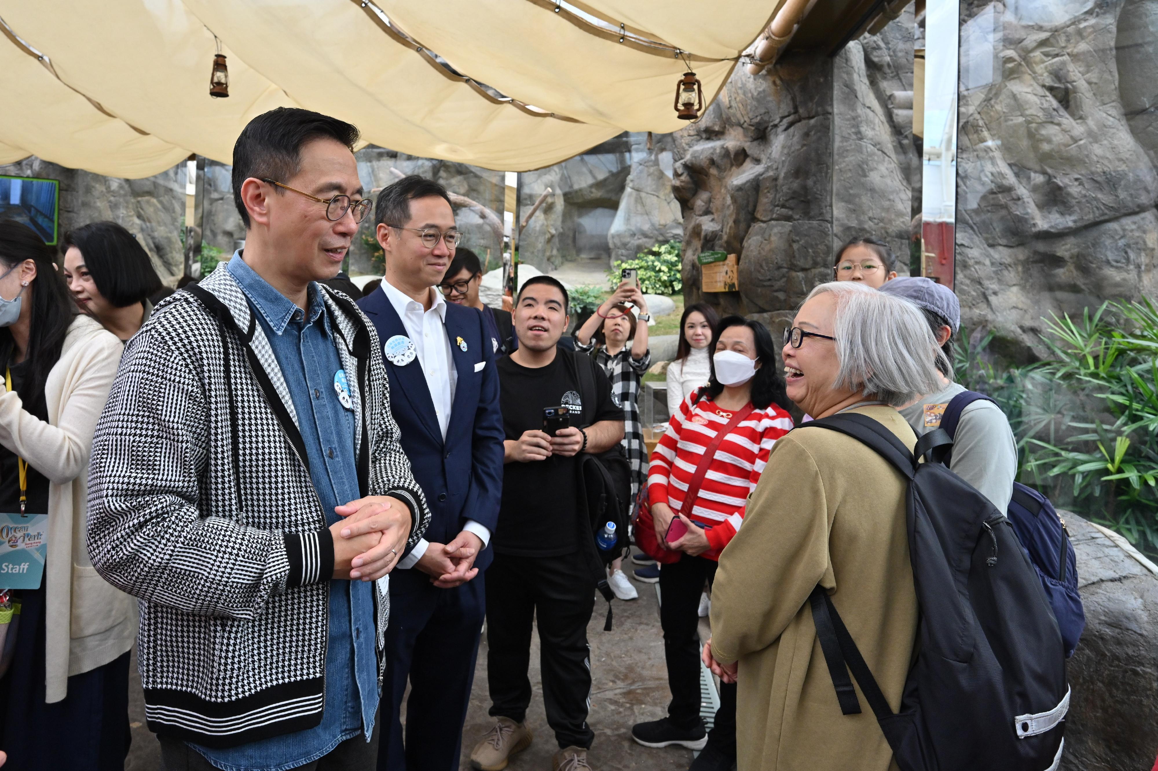 文化體育及旅遊局局長楊潤雄（左一）今日（十一月二十三日）到訪海洋公園，與探訪大熊貓樂樂的遊客閒談。