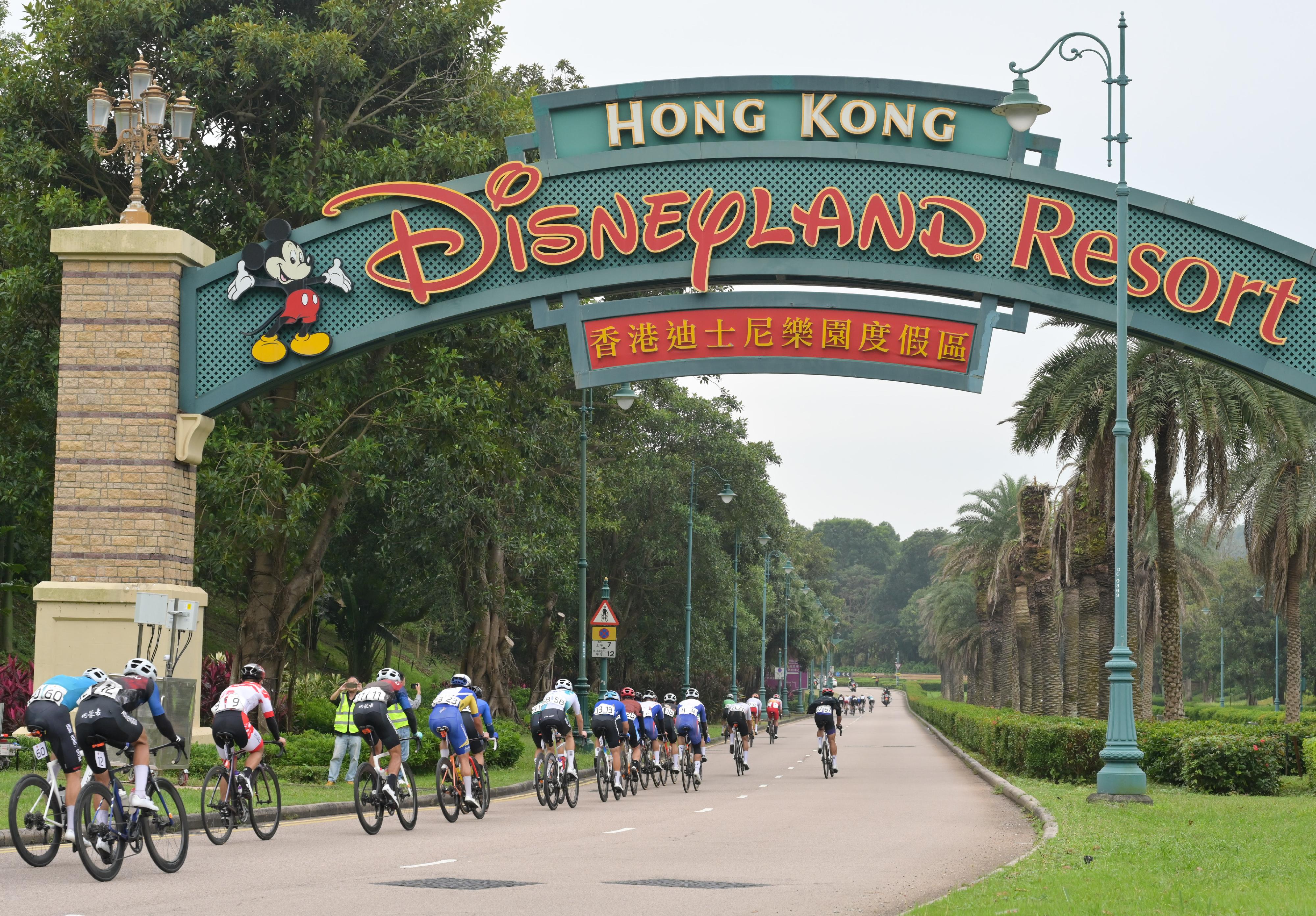 The 2024 Guangdong-Hong Kong-Macao Road Cycling Race and the 15th National Games road cycling test event was held today (November 24) in Zhuhai, Hong Kong and Macao's urban roads and the Hong Kong-Zhuhai-Macao Bridge. Photo shows road racers competing at the race route near the Hong Kong Disneyland Resort.