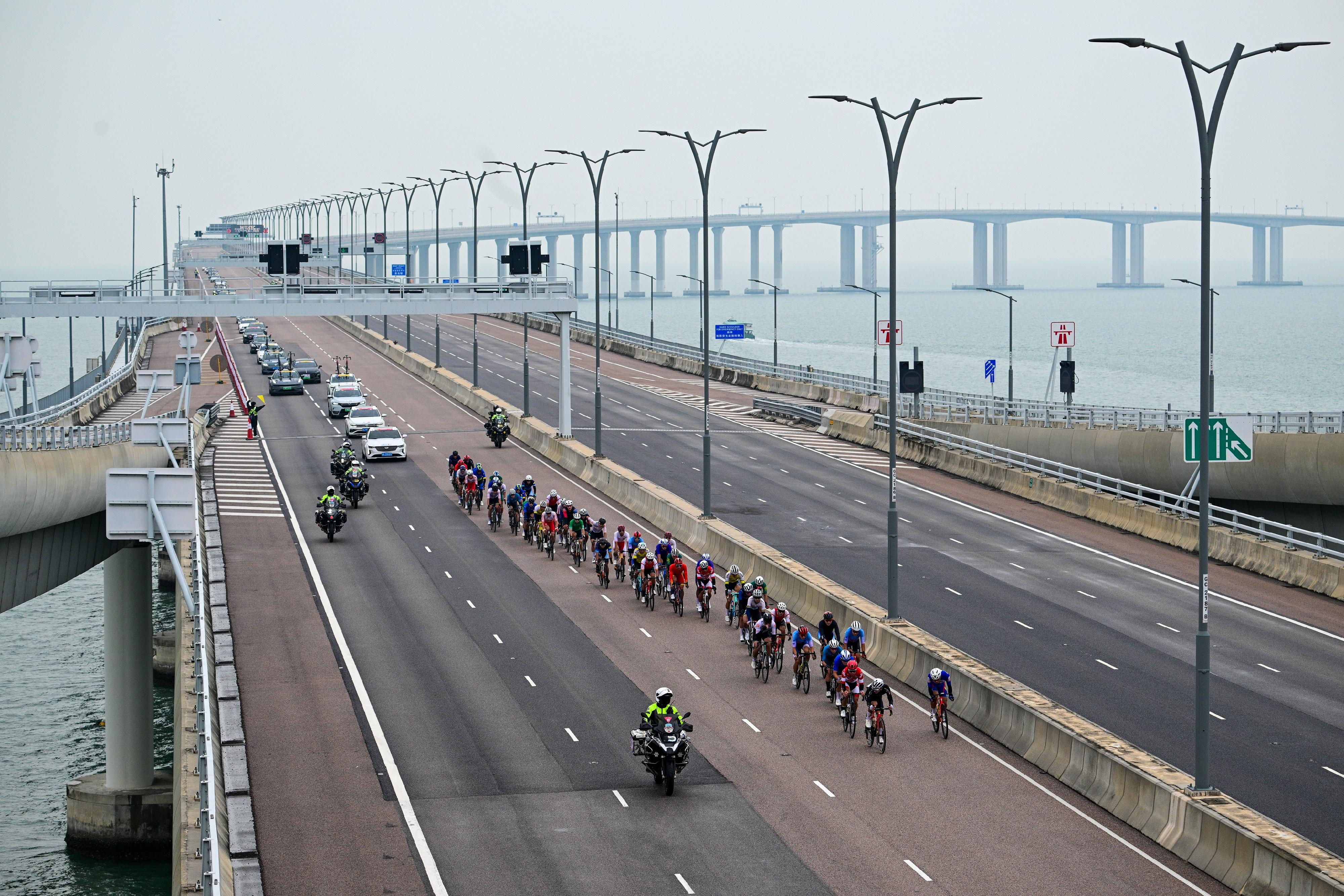 The 2024 Guangdong-Hong Kong-Macao Road Cycling Race and the 15th National Games road cycling test event was held today (November 24) in Zhuhai, Hong Kong and Macao's urban roads and the Hong Kong-Zhuhai-Macao Bridge. Photo shows the road racers entering Hong Kong section via the Hong Kong-Zhuhai-Macao Bridge.