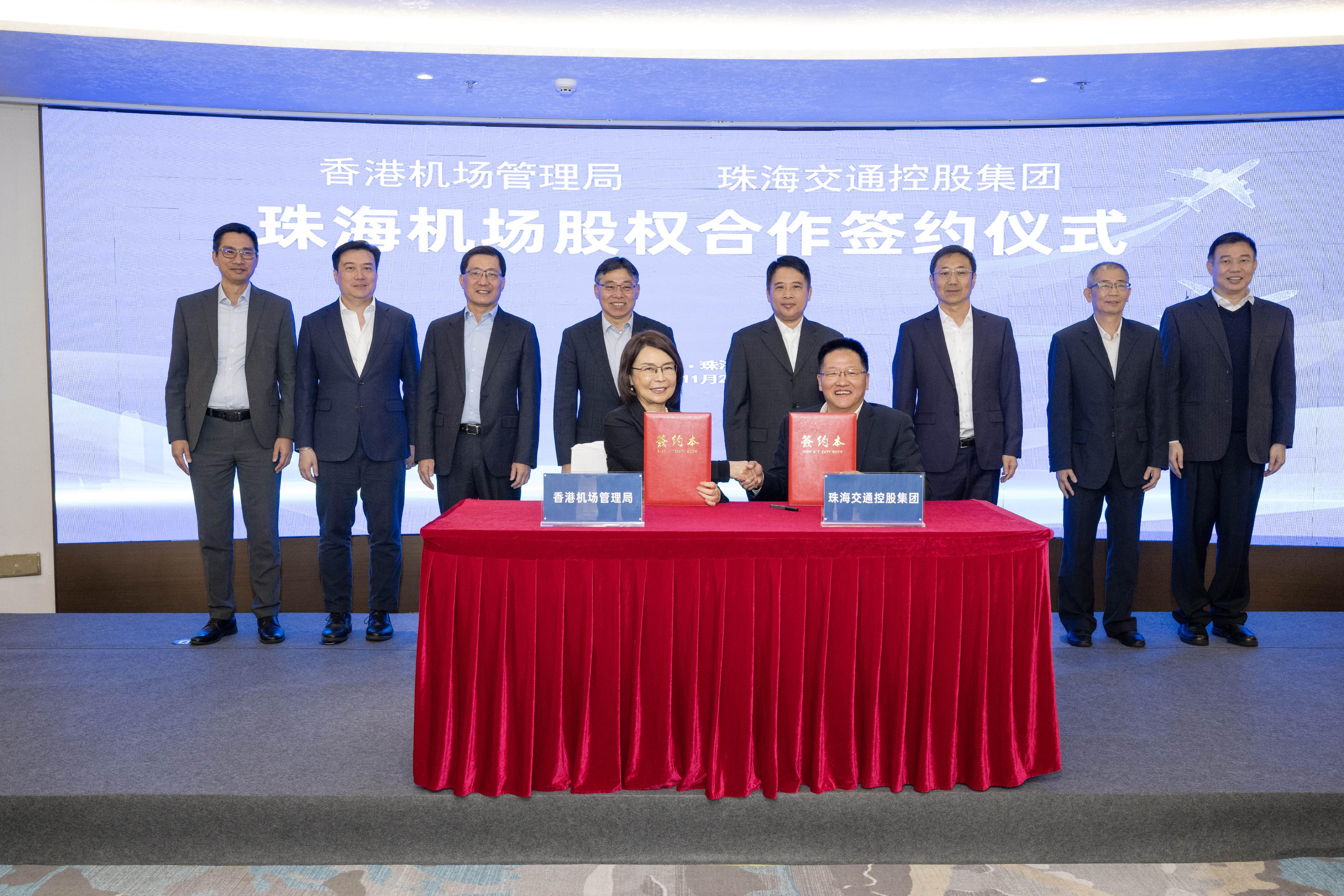 The Secretary for Transport and Logistics, Mr Lam Sai-hung, today (November 26) visited Zhuhai to attend the signing ceremony of the Airport Authority Hong Kong (AAHK)'s equity acquisition of Zhuhai Airport. Photo shows Mr Lam (back row, fourth left); Deputy Secretary of the Communist Party of China Zhuhai Municipal Committee and the Mayor of the Zhuhai Municipal Government, Mr Huang Zhihao (back row, fourth right); the Chairman of the AAHK, Mr Fred Lam (back row, third left), and other guests witnessing the signing of the Agreement of Shares Acquisition concerning the equity acquisition of Zhuhai Airport by the Acting Chief Executive Officer of the AAHK, Mrs Vivian Cheung (front row, left), and the Chairman of the Zhuhai Transportation Holdings Group, Mr Chen Weijia (front row, right).