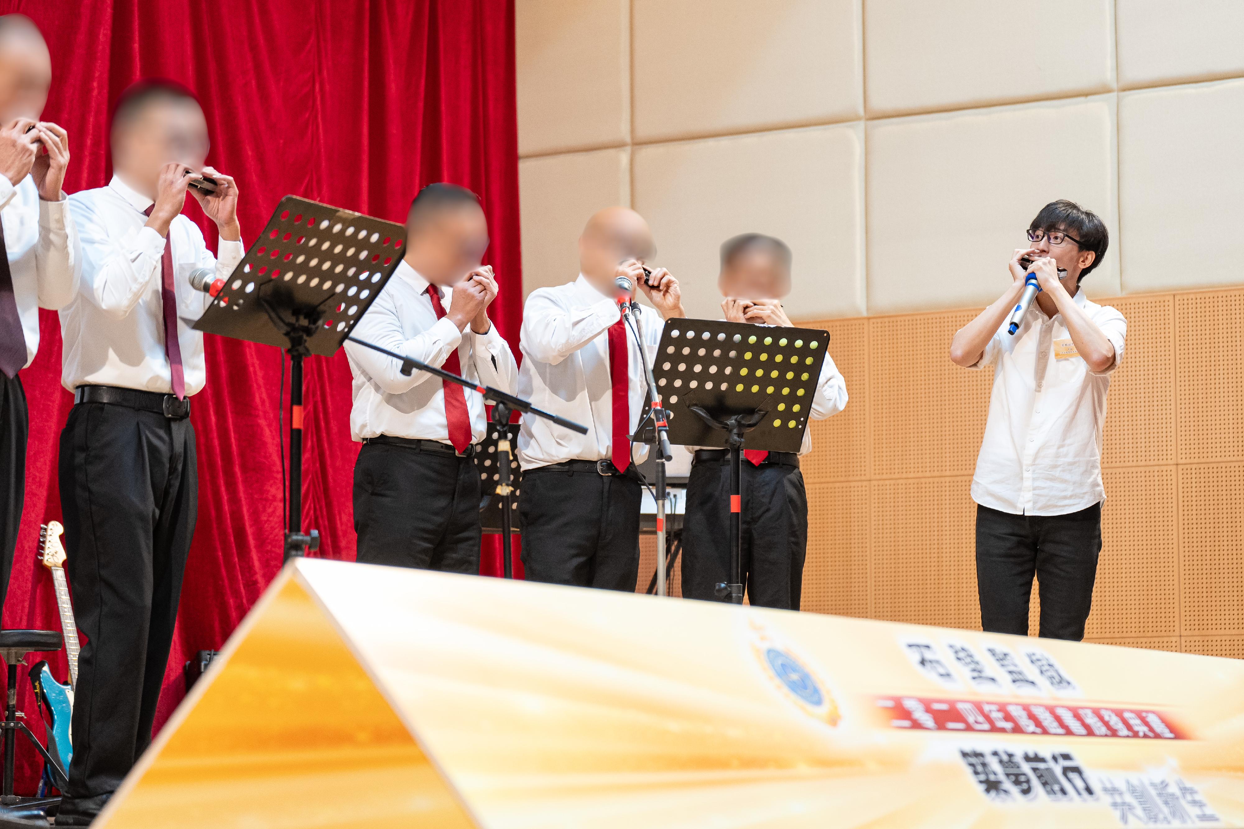 義工導師口琴演奏家梁栢渝（右一）夥拍在囚人士以口琴演奏樂曲。