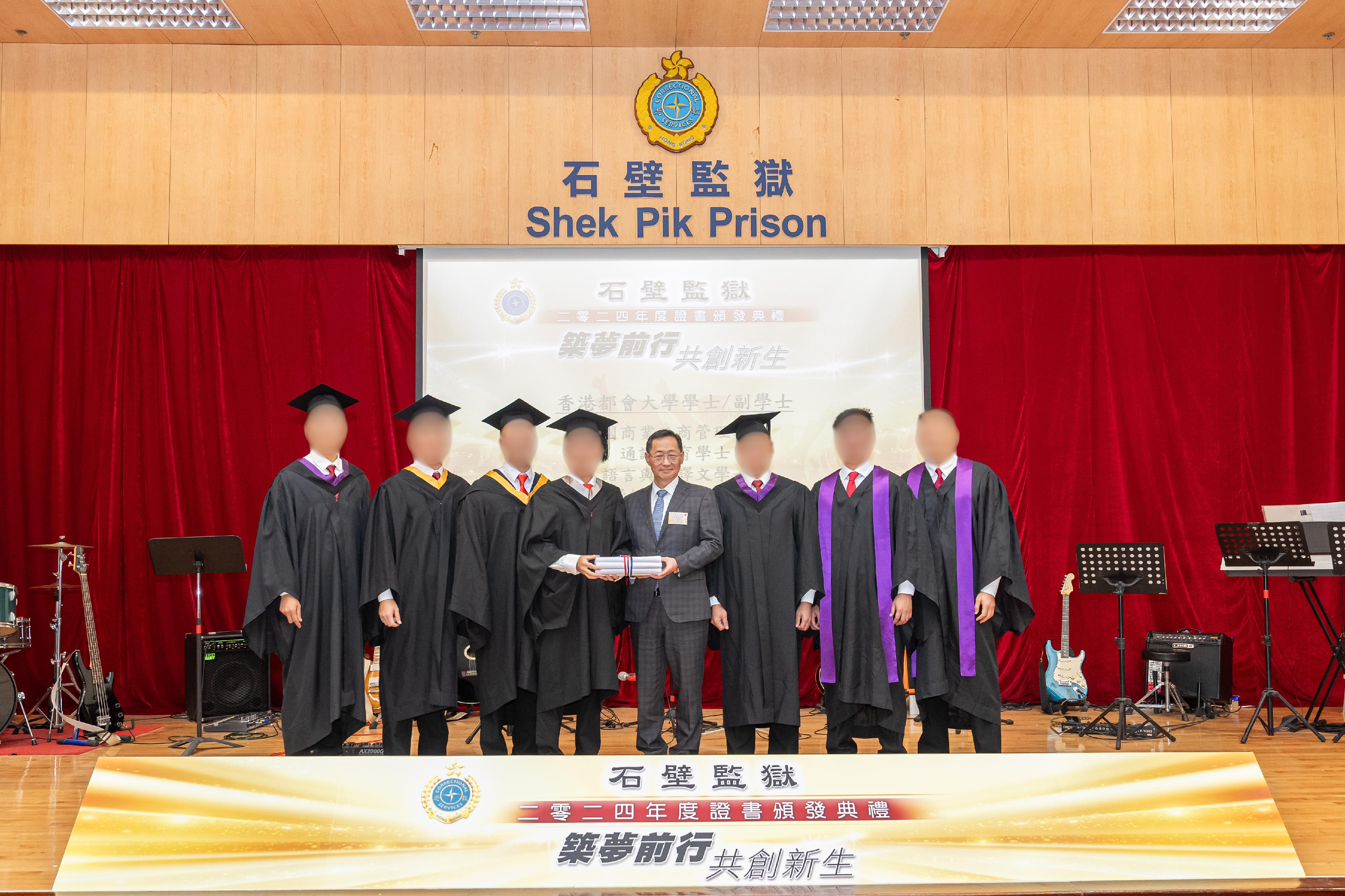 A total of 99 persons in custody at Shek Pik Prison of the Correctional Services Department were presented with certificates at a ceremony today (November 27) in recognition of their study efforts and academic achievements. Photo shows the Chairman of the Board of Directors of the Community Synergy for Rehabilitation Association, Dr Cook Chiu (fourth right), presenting certificates to persons in custody.