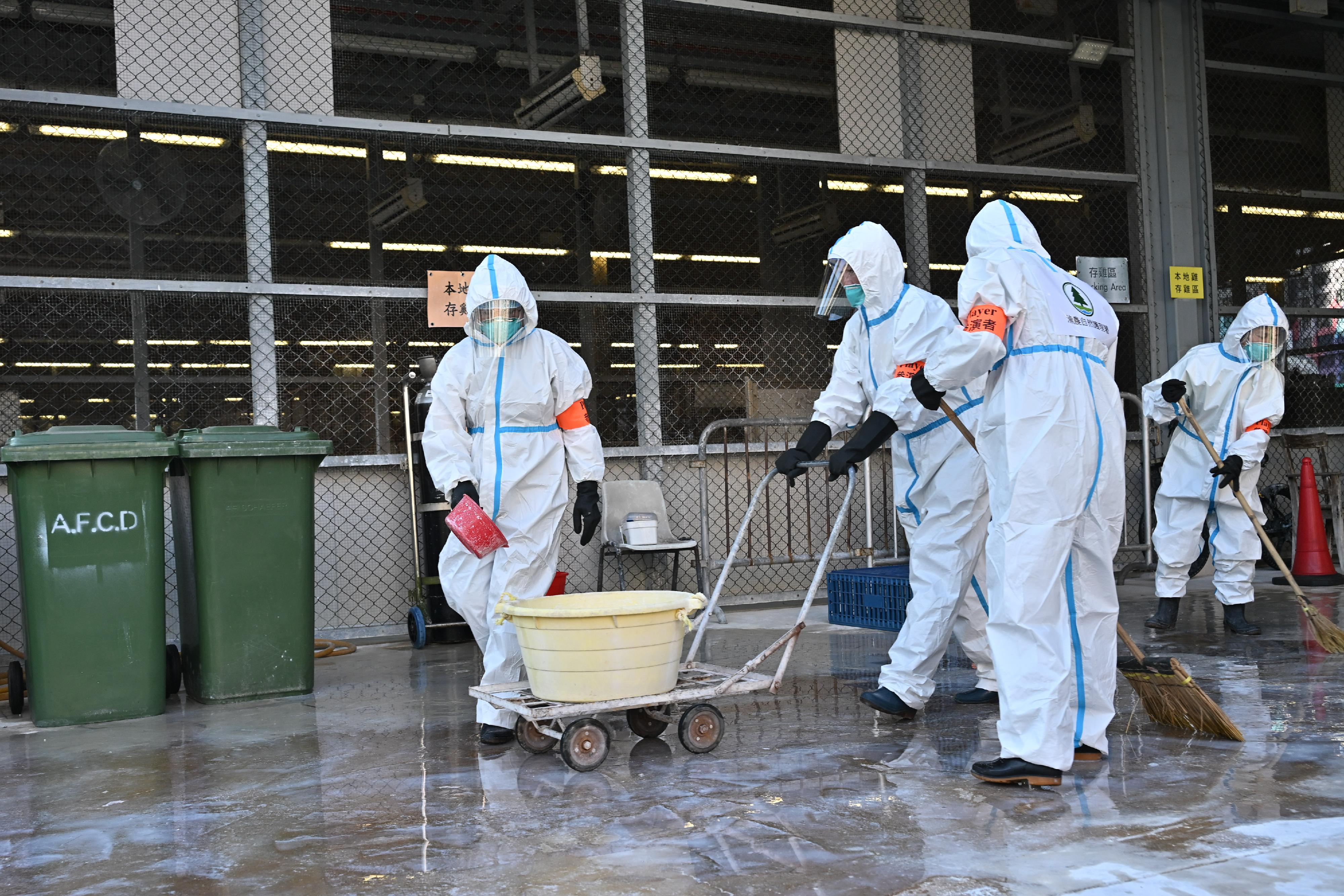 The Centre for Health Protection of the Department of Health, in collaboration with relevant government departments, today (November 27) conducted a public health exercise, code-named "Amazonite", to enhance its response capabilities in handling a human case of avian influenza infection.  Photo shows officers of the Agriculture, Fisheries and Conservation Department performing cleaning and disinfection procedures.