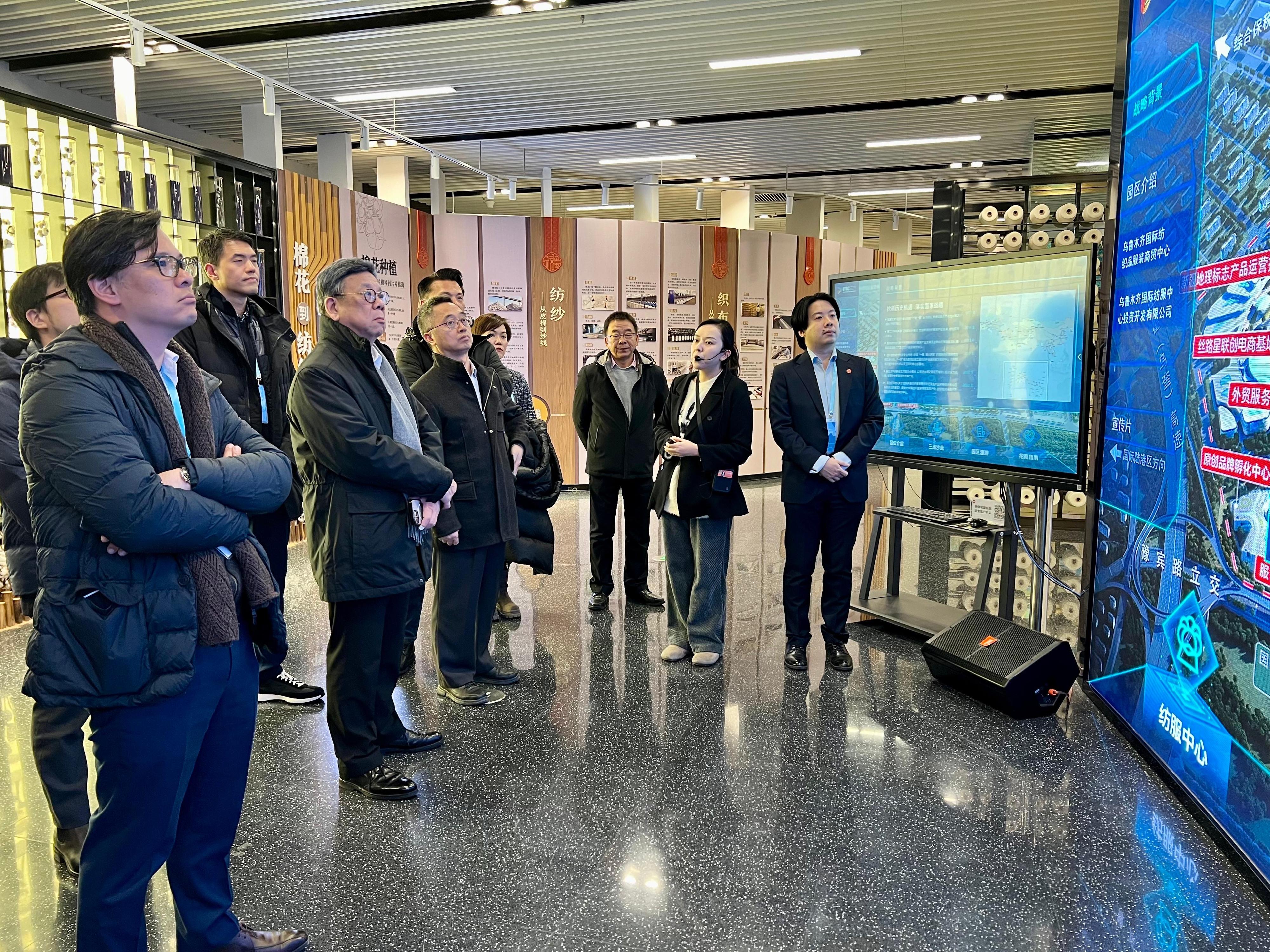 The Secretary for Commerce and Economic Development, Mr Algernon Yau, led a business delegation to visit Urumqi, Xinjiang. Photo shows Mr Yau (first row, second left) visiting the exhibition centre of textile and geographical indication products of Urumqi, Xinjiang, yesterday (December 4) to learn about the development of local specialty products.
