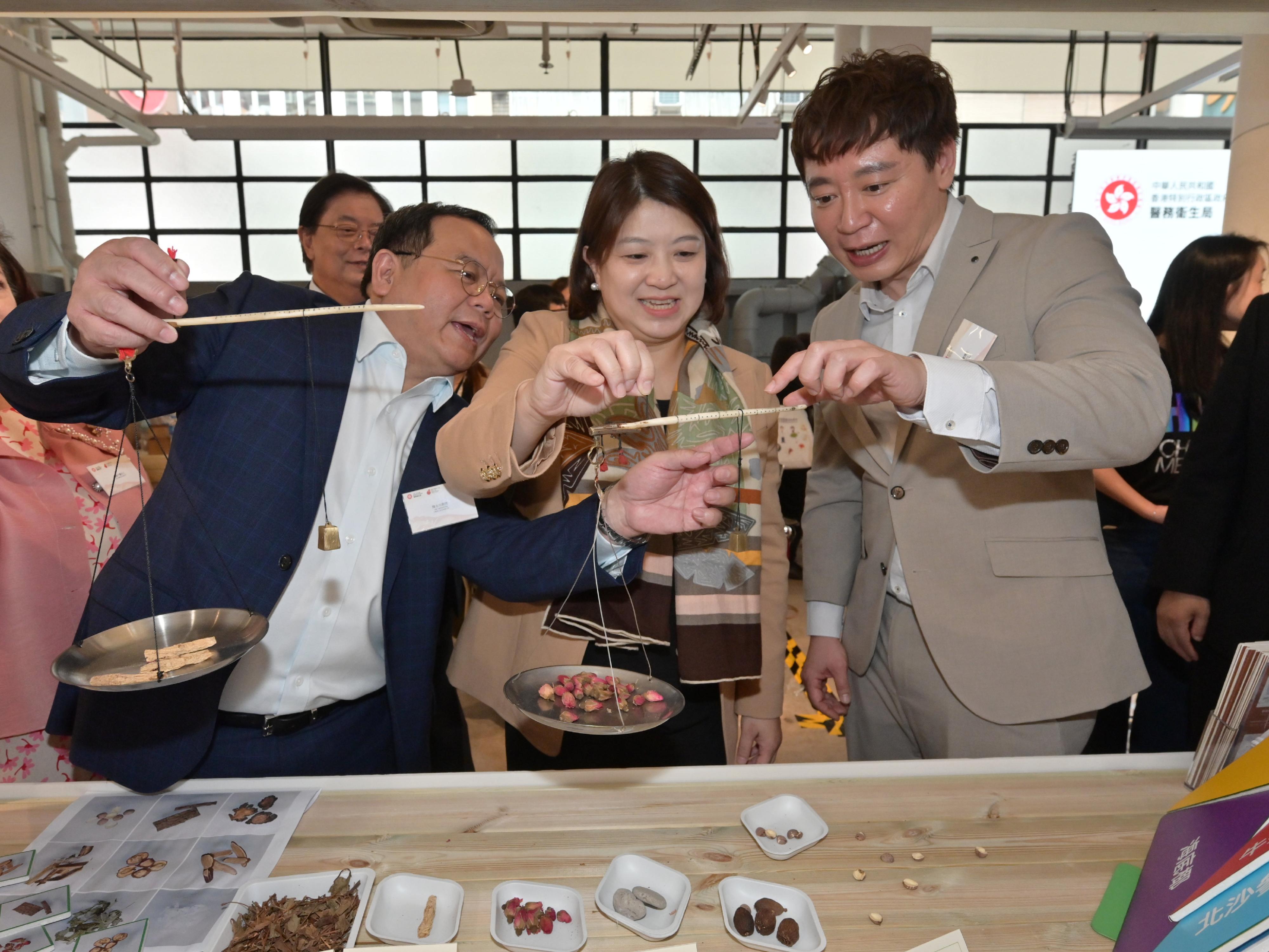 首届「香港中医药文化节」启动活动今日（十二月七日）起一连两日在中环街巿举行。图示署理医务卫生局局长李夏茵医生（中）与中医药发展专员钟志豪博士（右）和中医中药发展委员会辖下的中医业小组委员会主席陈永光教授（左）参观香港大学中医药学院的摊位。


