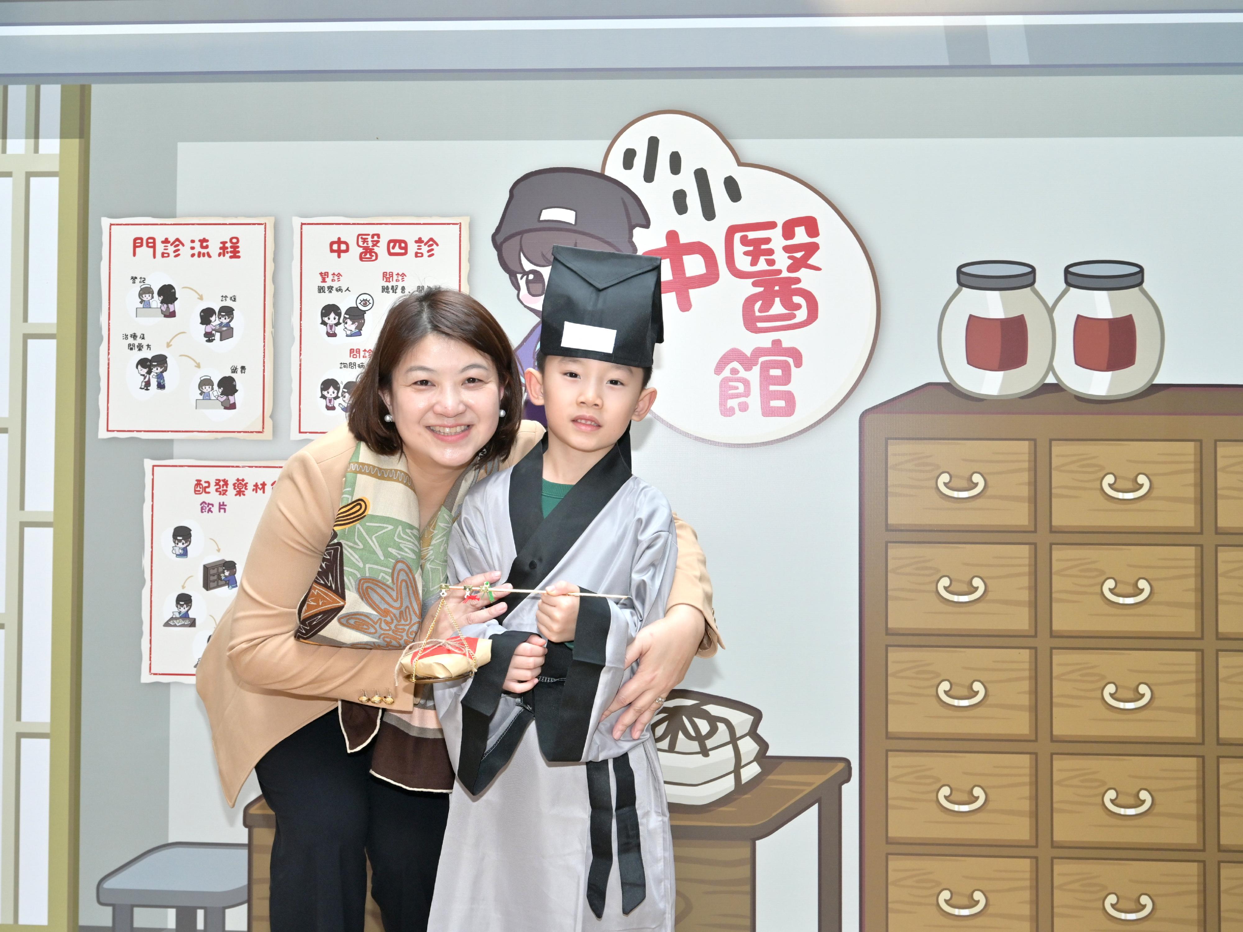 The kick-off event for the first Hong Kong Chinese Medicine Culture Festival is being held at the Central Market for two consecutive days starting today (December 7). Photo shows the Acting Secretary for Health, Dr Libby Lee (left), with a child dressed-up as a Chinese medicine practitioner during her tour at the booths.
