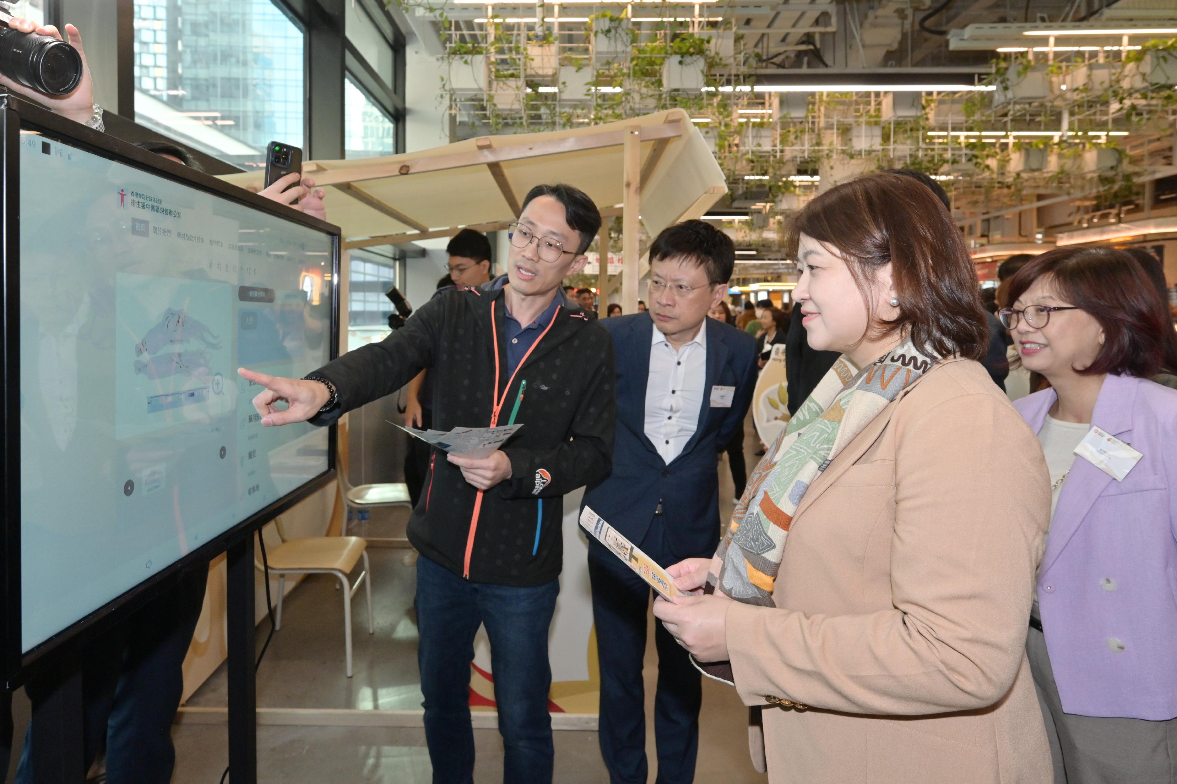 The kick-off event for the first Hong Kong Chinese Medicine Culture Festival is being held at the Central Market for two consecutive days starting today (December 7). Photo shows the Acting Secretary for Health, Dr Libby Lee (second right), learning about the dedicated website Digital Herbarium for Chinese Medicines established by the Department of Health.