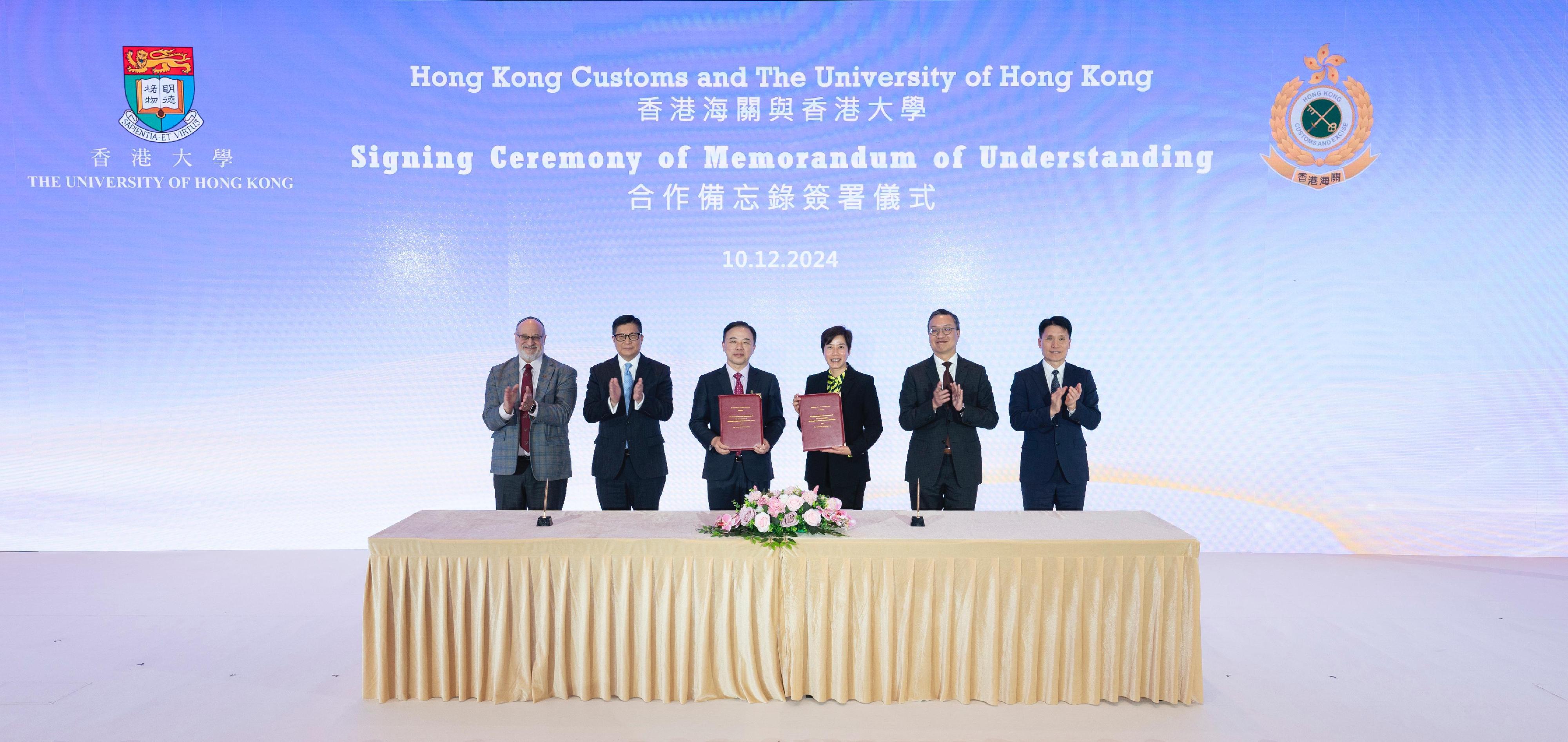 The Deputy Commissioner (Control and Enforcement) of Customs and Excise, Mr Mark Woo (first right), and the Dean of Engineering of the University of Hong Kong (HKU), Professor David Srolovitz (first left), today (December 10) signed a Memorandum of Understanding (MOU) to promote technological innovation in the areas of Customs services during the three-day International Forum on Combating Money Laundering and Transnational Organized Crimes. The Secretary for Justice, Mr Paul Lam, SC (second right); the Secretary for Security, Mr Tang Ping-keung (second left); the Commissioner of Customs and Excise, Ms Louise Ho (third right); the President and Vice-Chancellor of the HKU, Professor Xiang Zhang (third left); Mr Woo and Professor Srolovitz took a group photo after the signing of the MOU.