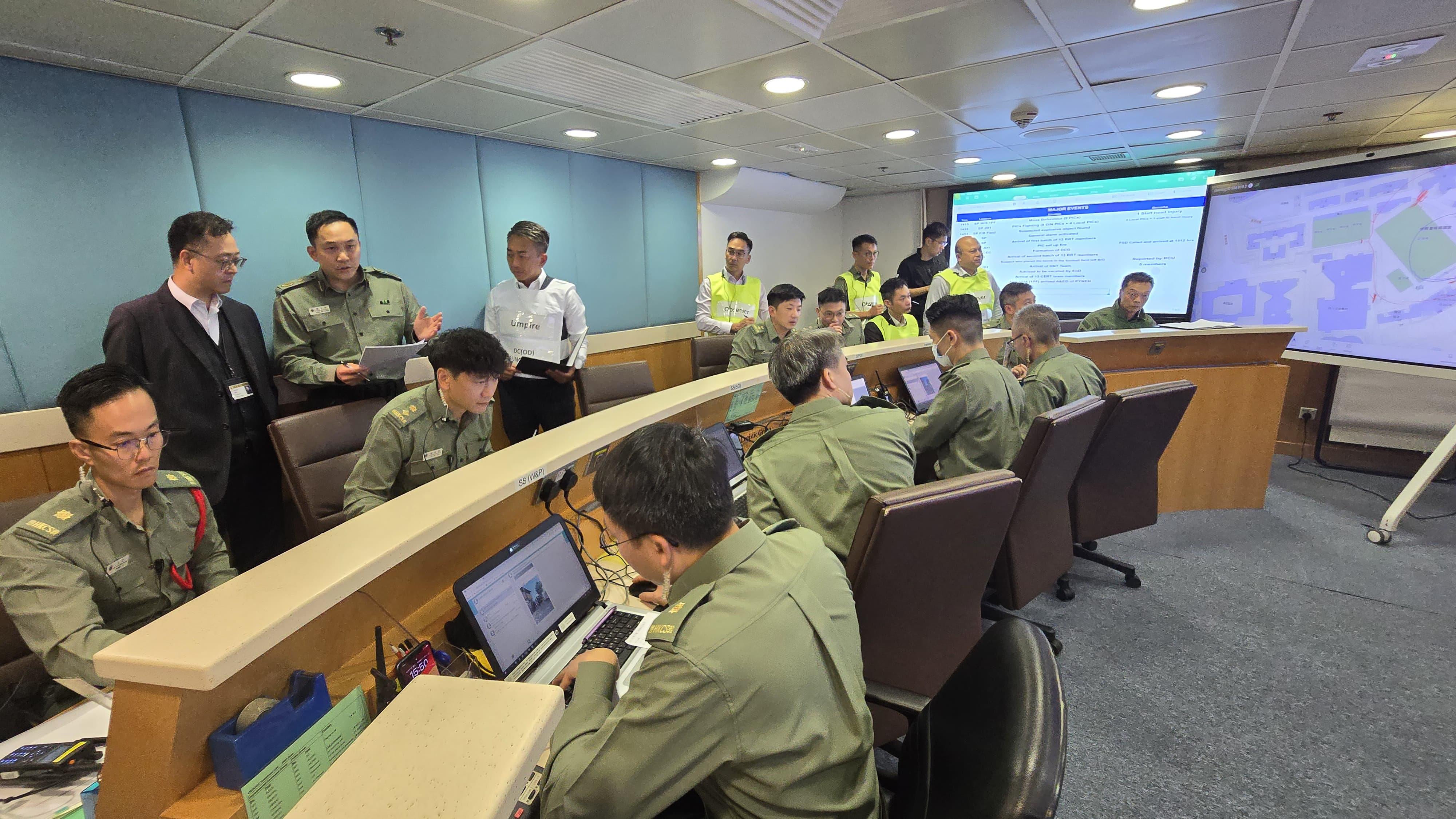 The Correctional Services Department conducted an emergency exercise, code-named Concord XXIII, today (December 11). The exercise simulated a series of incidents, including mass indiscipline of persons in custody, a hostage-taking situation, assembly of members of the public intruding into a restricted area, and the discovery of explosives at Stanley Prison. Photo shows the Commissioner of Correctional Services, Mr Wong Kwok-hing (back row, first left), visiting the Department's Central Control Centre in Stanley and being briefed by the Commander of the exercise, the Assistant Commissioner of Correctional Services (Operations), Mr Chan Siu-hang (back row, second left), on the operation of the exercise.