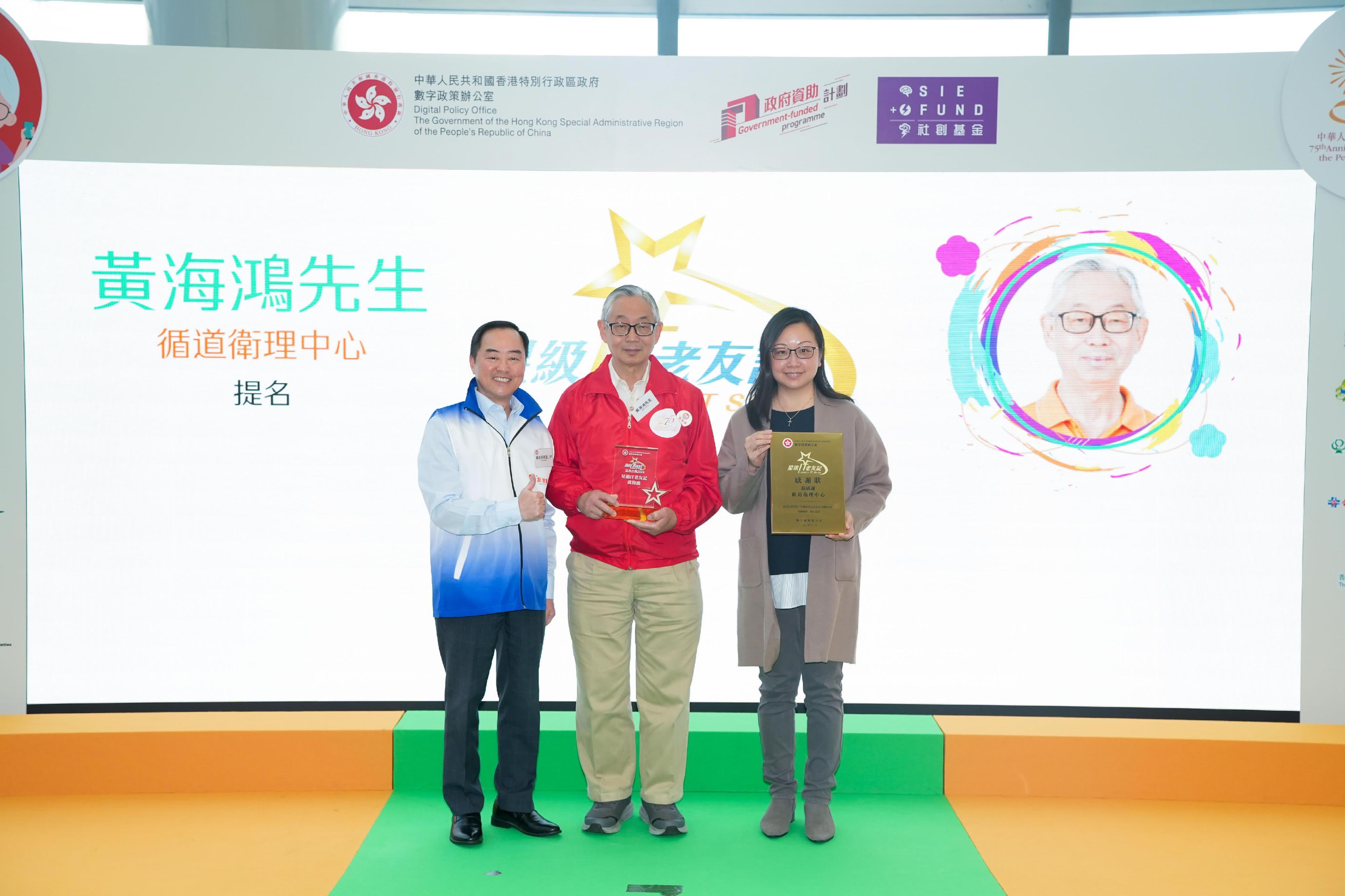 The Commissioner for Digital Policy, Mr Tony Wong (left), presents awards to awardees of the Elderly IT Stars Recognition Scheme today (December 13).
