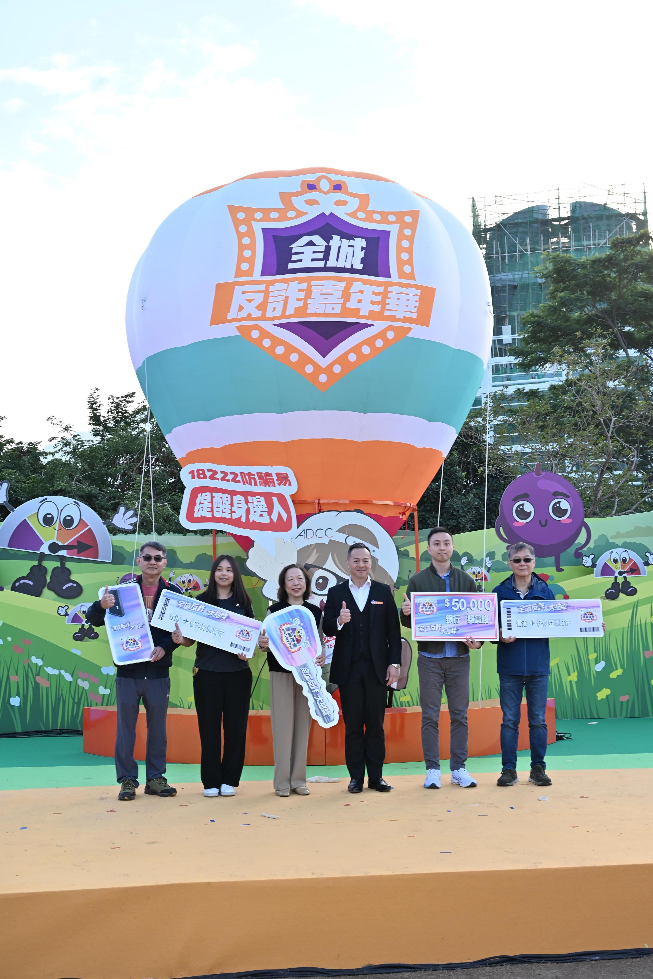 The Commercial Crime Bureau, the Cyber Security and Technology Crime Bureau and the Financial Intelligence and Investigation Bureau of the Hong Kong Police Force held the Anti-Scam Carnival at the West Kowloon Cultural District today (December 14). Photo shows the Deputy Commissioner of Police (Operations), Mr Chow Yat-ming (third right), presenting prizes to the winners of the Anti-scam Lucky Draw.