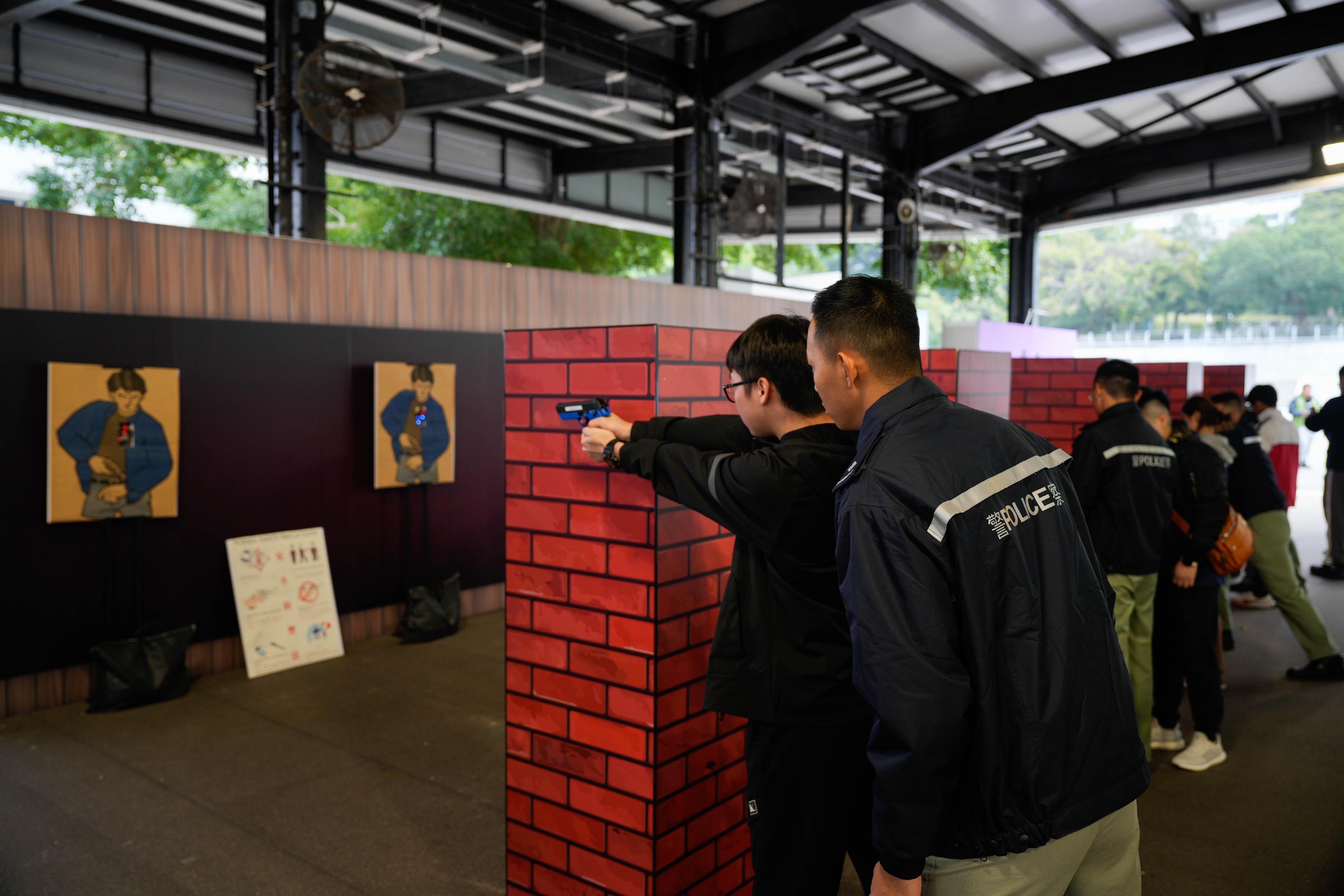 參加者於模擬靶場體驗學警槍械射擊訓練。