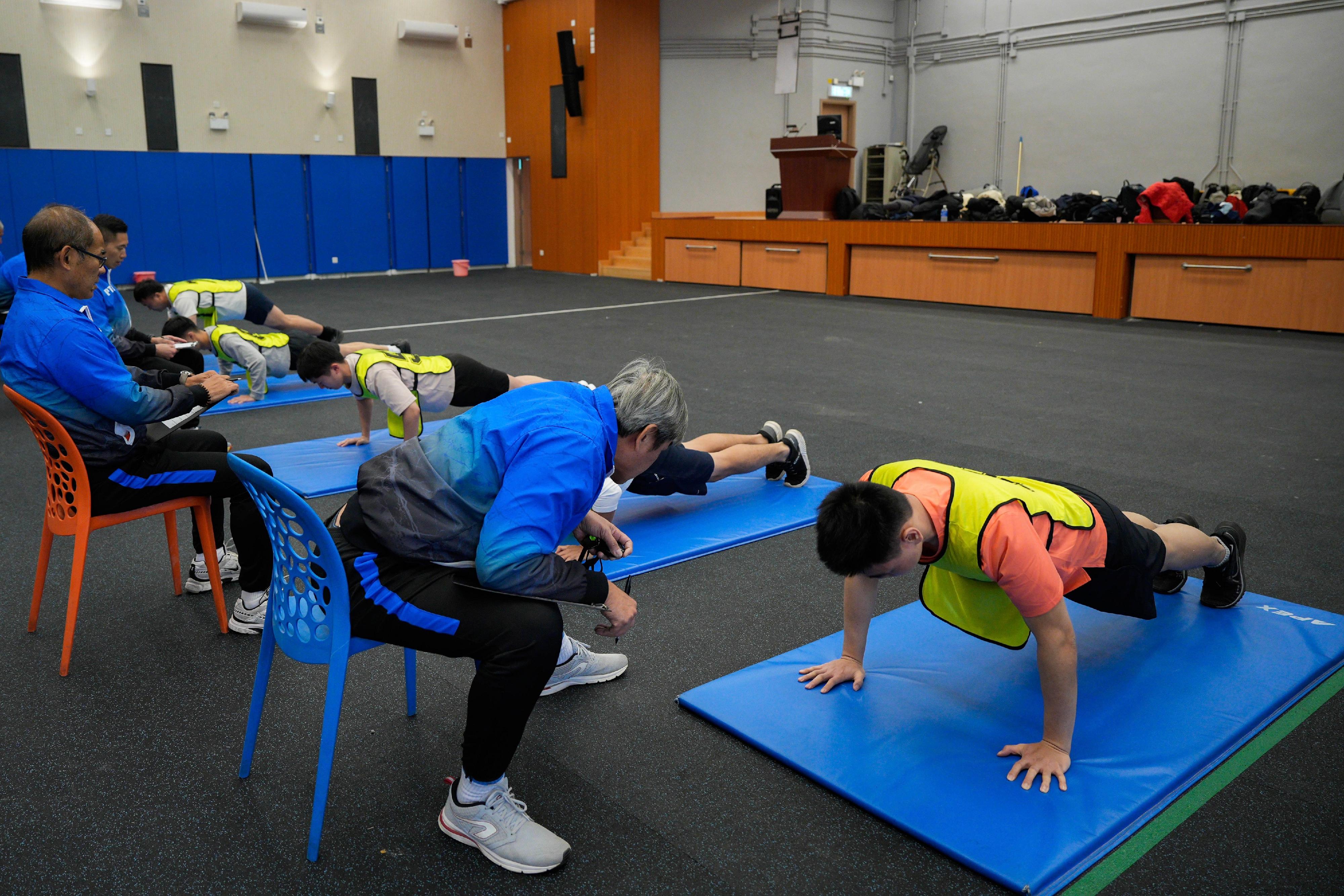 The Hong Kong Police Force today (December 15) held the Police Recruitment Experience and Assessment Day at the Hong Kong Police College. Photo shows participants taking part in the push-up challenge during the physical fitness test workshop.