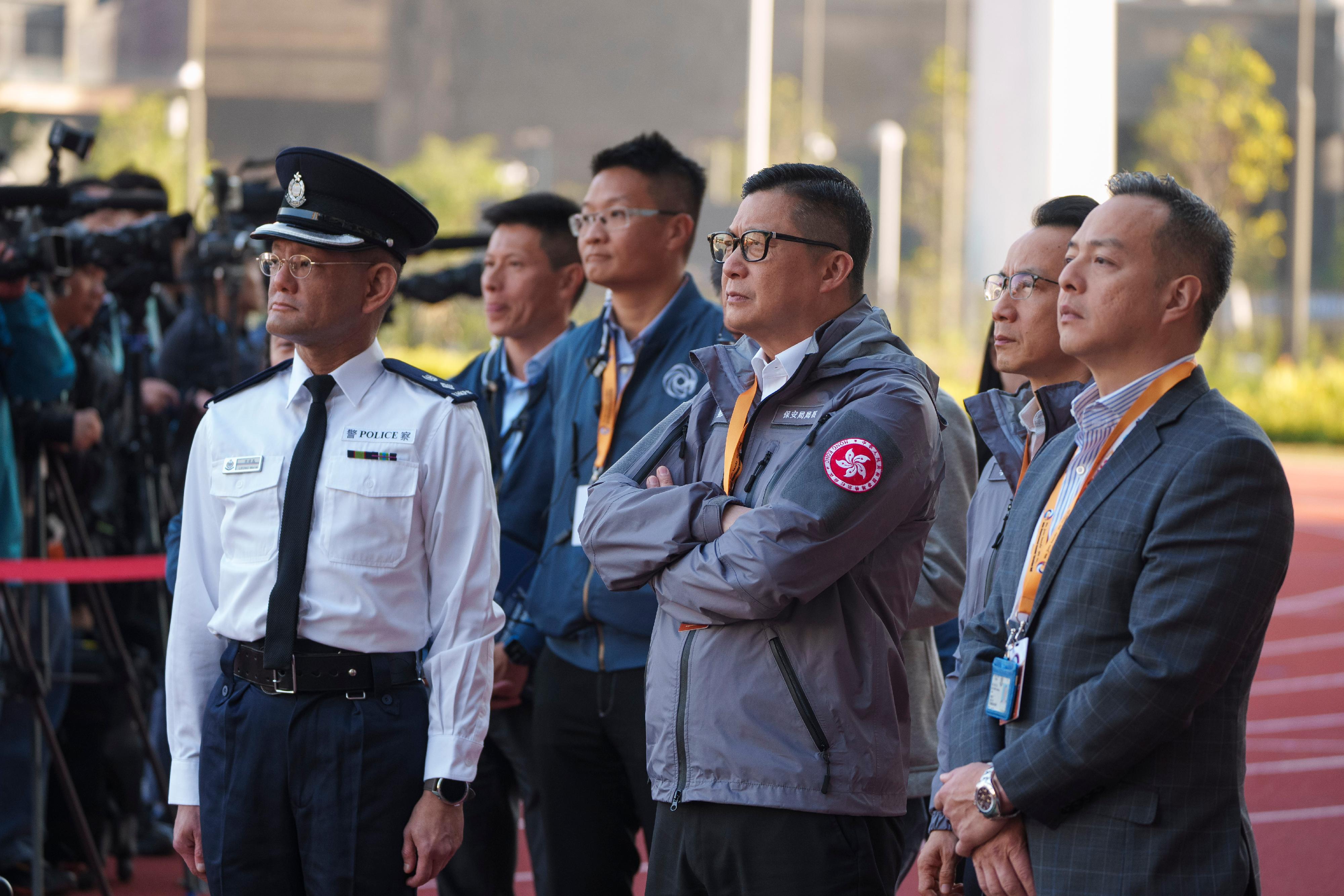 跨部门反恐专责组今日（十二月十七日）下午在启德青年运动场进行代号「慧光」的跨部门反恐演习。图示保安局局长邓炳强（右三）、保安局常任秘书长李百全（右二）、警务处副处长（行动）周一鸣（右一）及跨部门反恐专责组高级警司梁伟基（左一）视察演习情况。