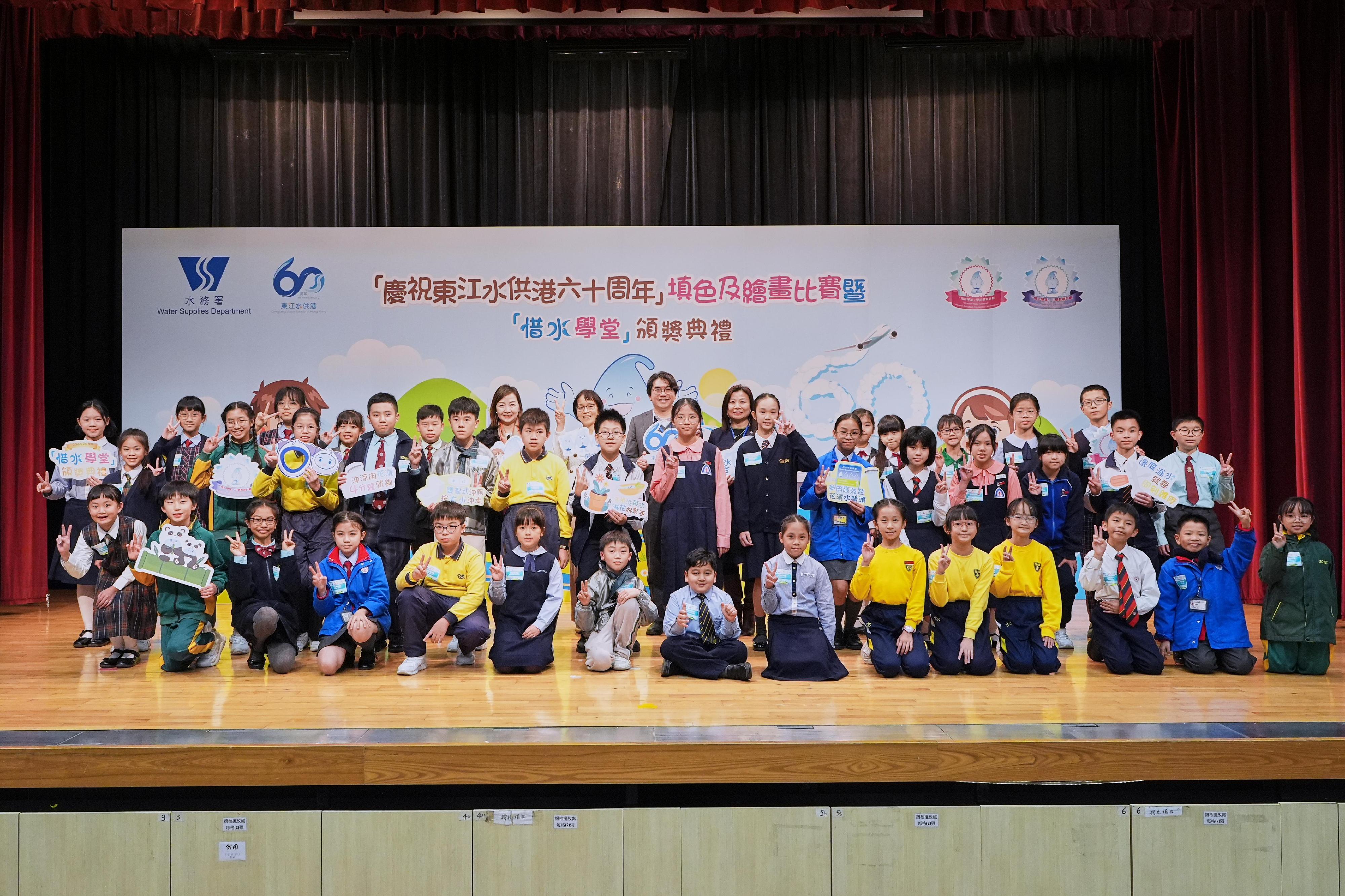 水务署今日（十二月十八日）举行「庆祝东江水供港六十周年」填色及绘画比赛暨「惜水学堂」颁奖典礼，以表扬学校及师生对「庆祝东江水供港六十周年」活动及在节约用水方面所作出的努力。图示水务署署长黄恩诺（后排右二）与节约用水智叻星得奖学生合照。