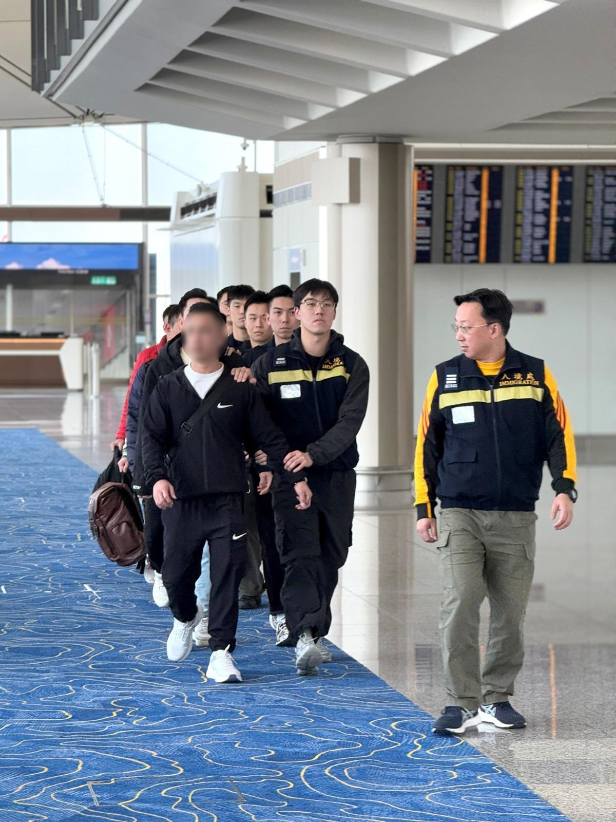 The Immigration Department (ImmD) carried out a repatriation operation today (December 18).  A total of 18 Vietnamese illegal immigrants and overstayers were repatriated to Vietnam. Photo shows removees being escorted by ImmD officers to depart from Hong Kong.

