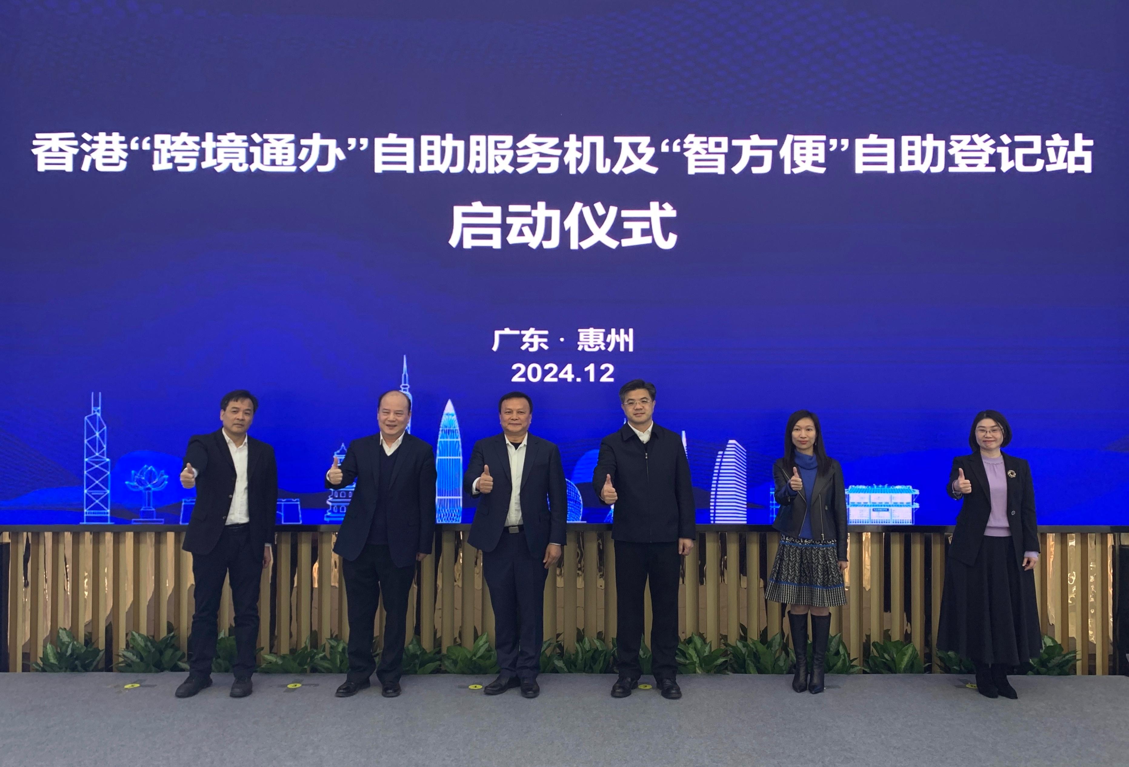 The Hong Kong Special Administrative Region Government has set up a Hong Kong Cross-boundary Public Services self-service kiosk and an "iAM Smart" self-registration kiosk at the Huizhou Civic Center. Photo shows representatives of the Guangdong Provincial Administration of Government Service and Data and the Digital Policy Office, with other guests at the launch event today (December 20).