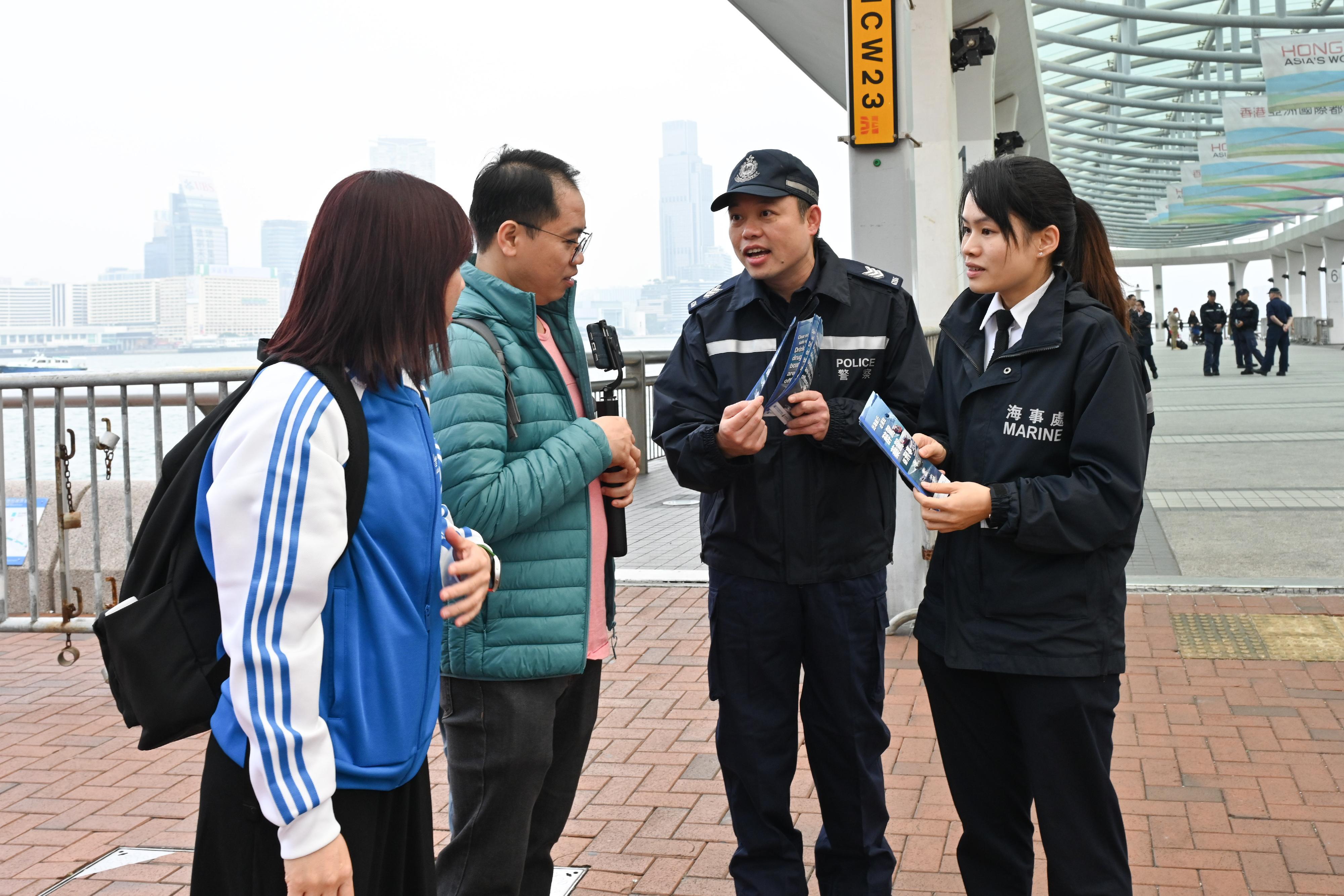 为提高市民对海上醉驾和药驾的意识，海事处和香港警务处今日（十二月二十七日）在中环九号及十号码头向市民派发单张，宣传《海上安全（酒精及药物）条例》。图示执法人员向市民解释有关法例。