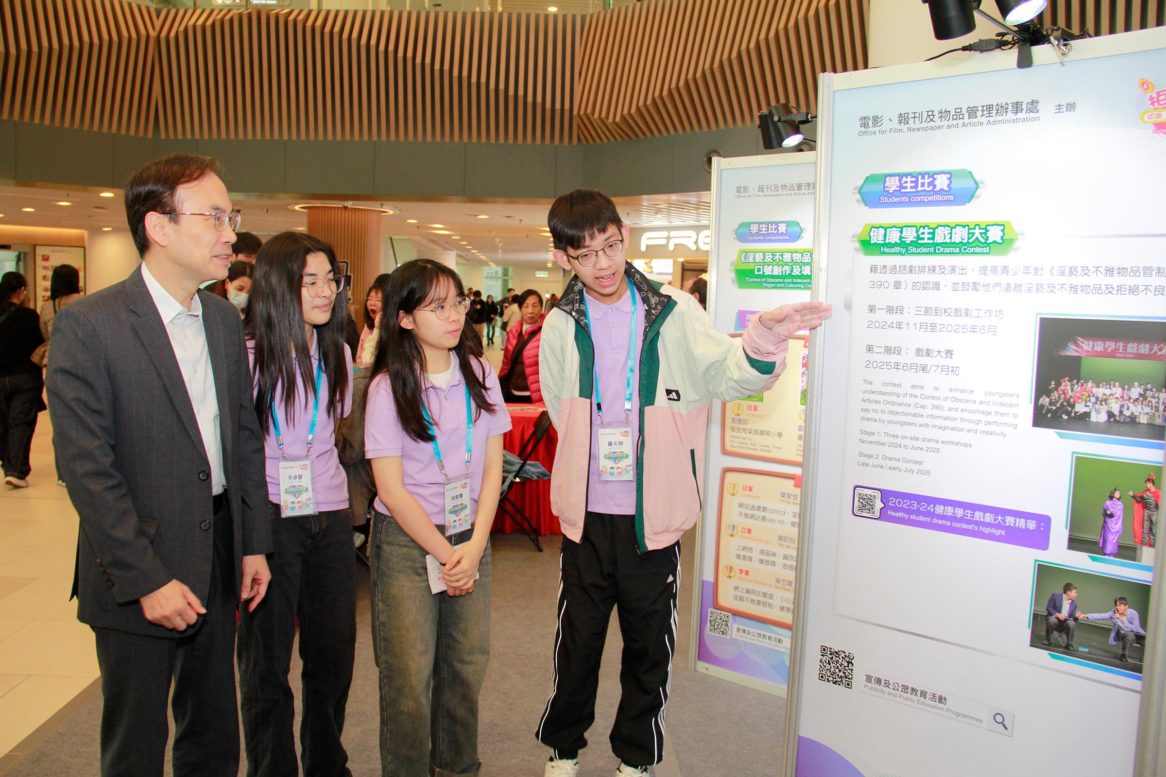 The Office for Film, Newspaper and Article Administration is holding an exhibition themed "Saying NO to Objectionable Information" for three consecutive days starting from today (December 27) to enhance the public's understanding of the Control of Obscene and Indecent Articles Ordinance. Photo shows the Director of Film, Newspaper and Article Administration, Mr Chaucer Leung (first left), being briefed on the exhibition panels by Healthy Information Student Ambassadors at the exhibition.