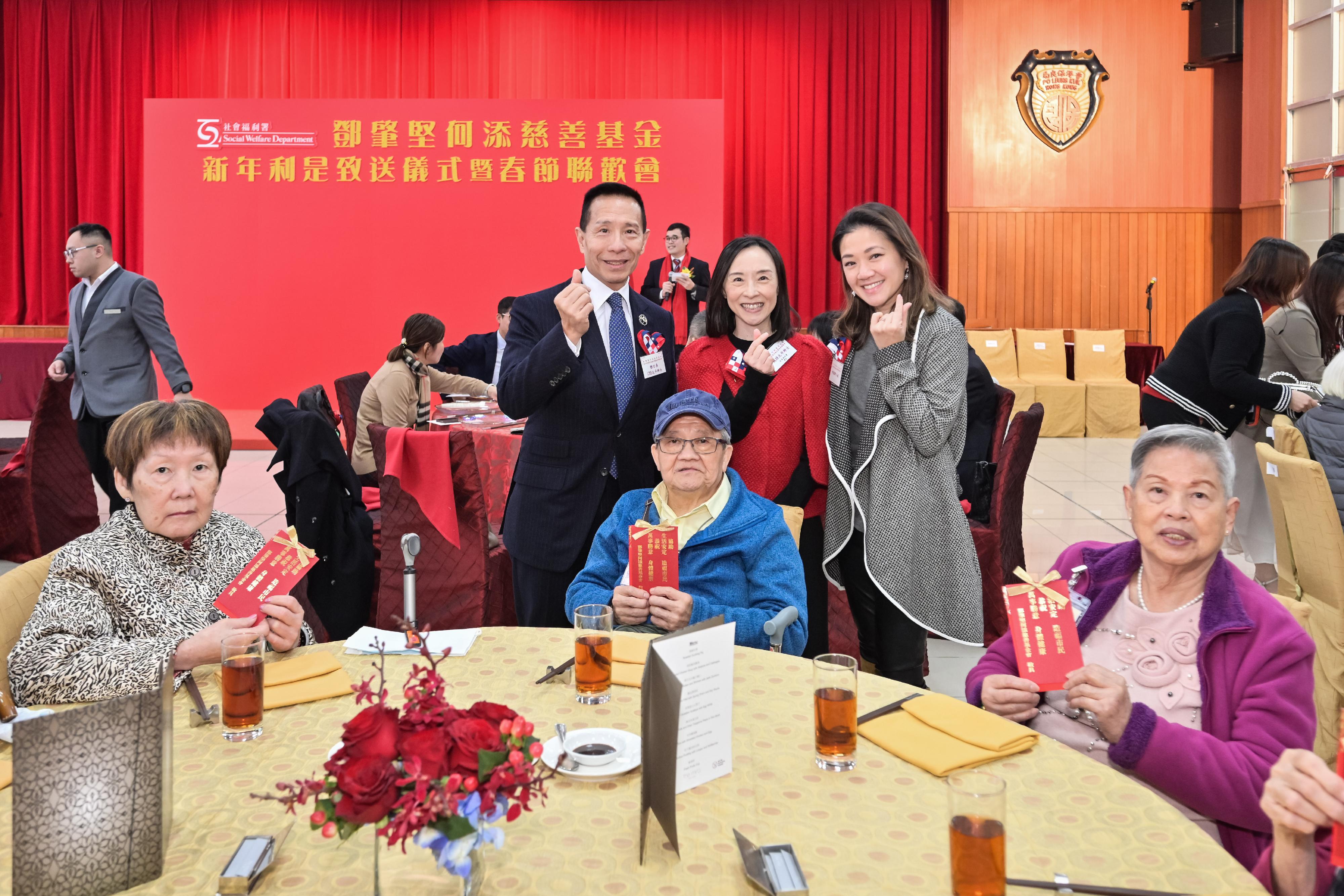 The Social Welfare Department and the Management Committee of the Tang Shiu Kin and Ho Tim Charitable Fund today (January 7) jointly hosted a spring reception for the elderly and presented lai see packets to them in celebration of the upcoming Lunar New Year. Photo shows the Director of Social Welfare, Miss Charmaine Lee (back row, centre), together with the descendants of the Fund's founders, Mr Richard Tang (back row, left) and Miss Veronica Ho (back row, right), greeting elderly participants with lai see packets in celebration of the coming Lunar New Year. 
