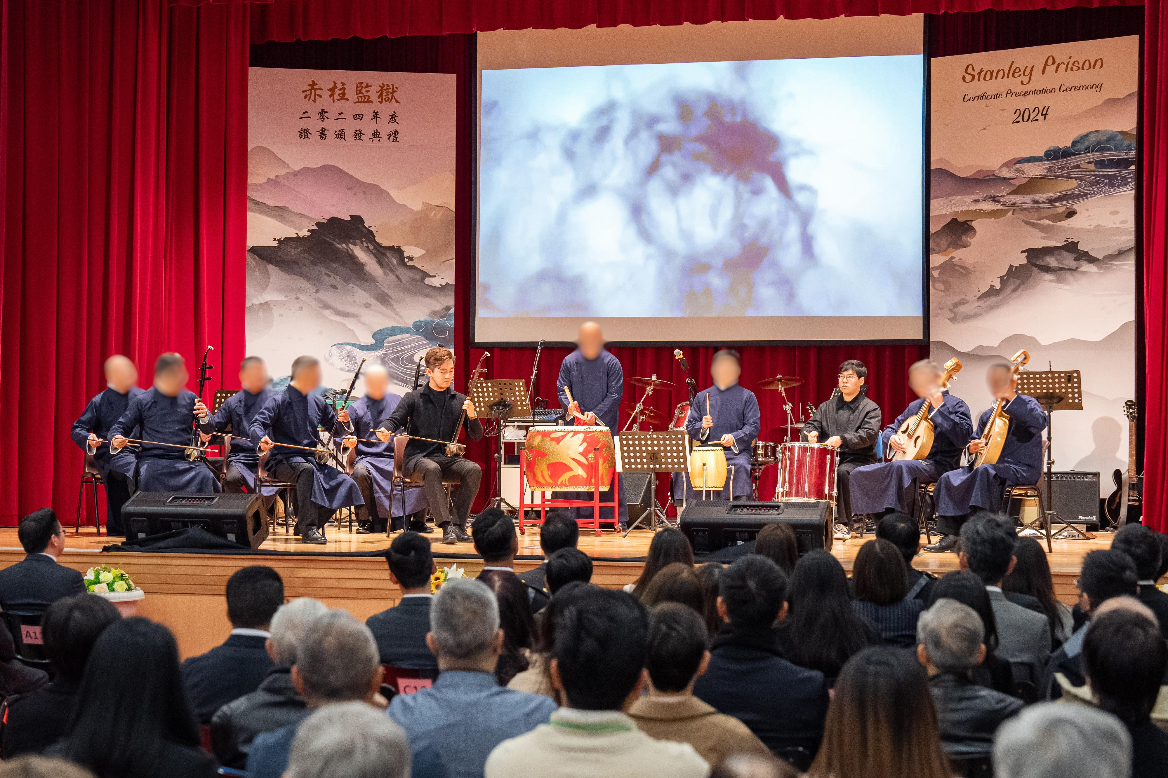 惩教署辖下的赤柱监狱今日（一月八日）举行证书颁发典礼，颁发学业证书予在囚人士，肯定他们在学业上努力进修的成果。图示在囚人士与中乐导师江建彬（左六）和杨俊轩（右三）合奏表演。