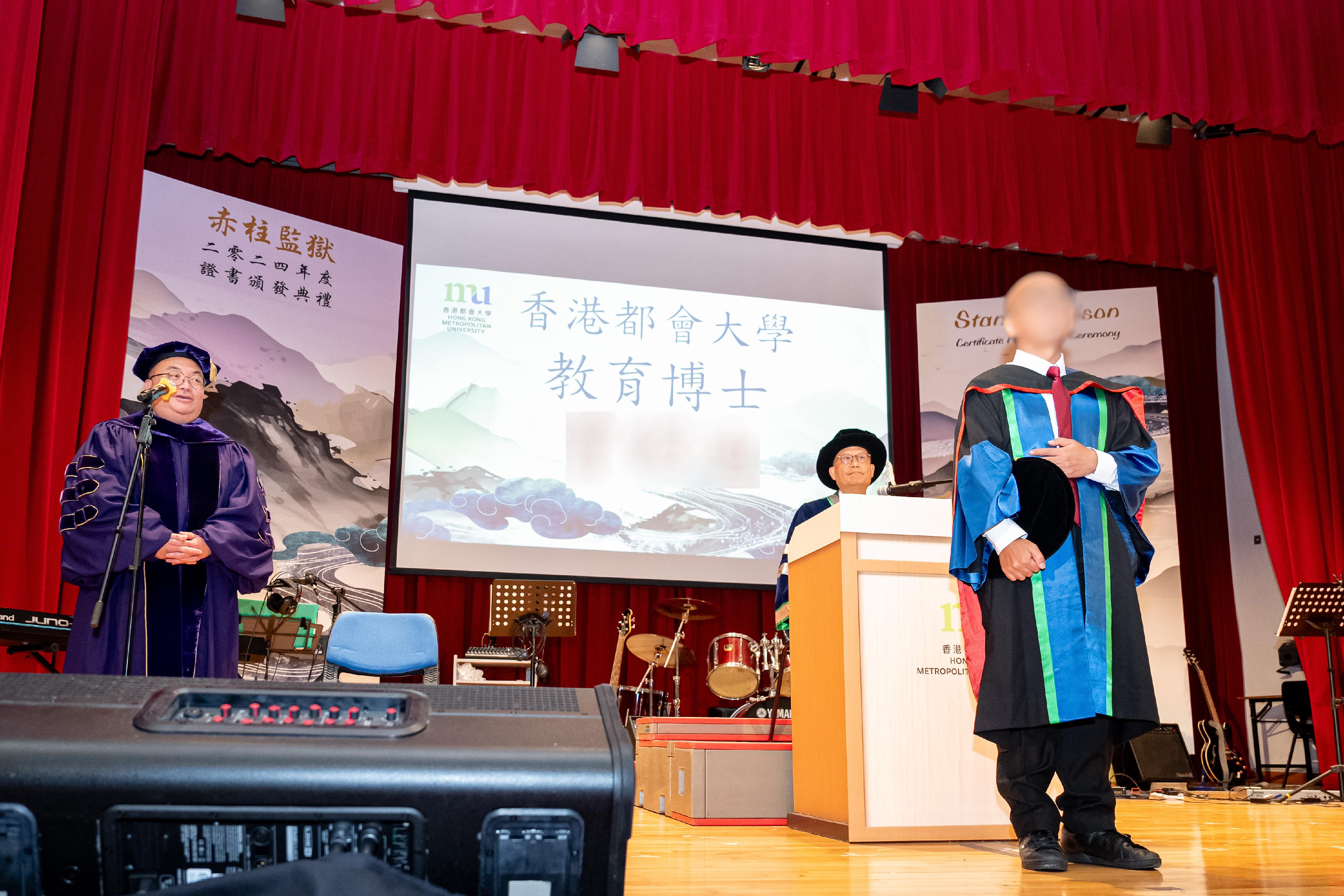 Persons in custody at Stanley Prison of the Correctional Services Department were presented with certificates at a ceremony today (January 8) in recognition of their continuous efforts in pursuing further studies. Photo shows the President of the Hong Kong Metropolitan University, Professor Paul Lam (centre), and the Dean of School of Education and Languages of the Hong Kong Metropolitan University, Professor Andy Chin (left), conferring a doctoral degree on a person in custody.