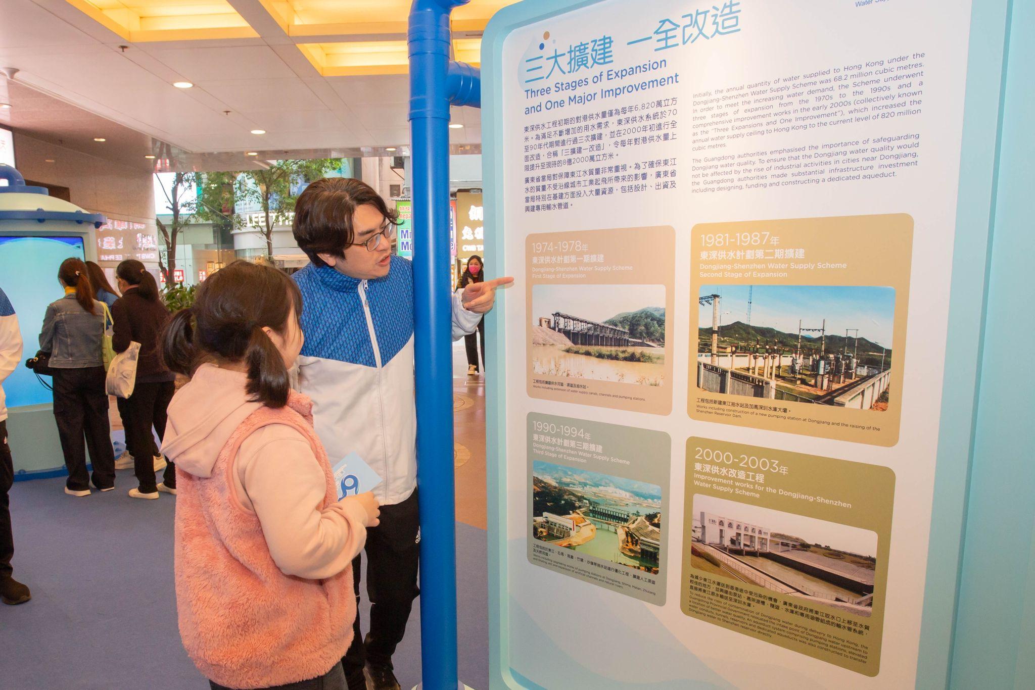 To deepen the public's understanding of the history, development and current situation of Dongjiang water supply to Hong Kong, the Water Supplies Department is holding the "Roving Exhibition on the 60th Anniversary of Dongjiang Water Supply to Hong Kong" in the covered piazza, Times Square, Causeway Bay, from today (January 11) until January 19. Photo shows the Director of Water Supplies, Mr Roger Wong (first right), introducing the content of the exhibition to the public.
