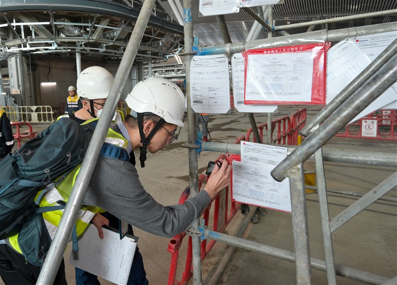 The Deputy Commissioner for Labour (Occupational Safety and Health), Mr Vincent Fung, inspected a construction site at the airport in Chek Lap Kok today (January 16). Photo shows officers of the Labour Department inspecting a metal scaffold of the construction site.