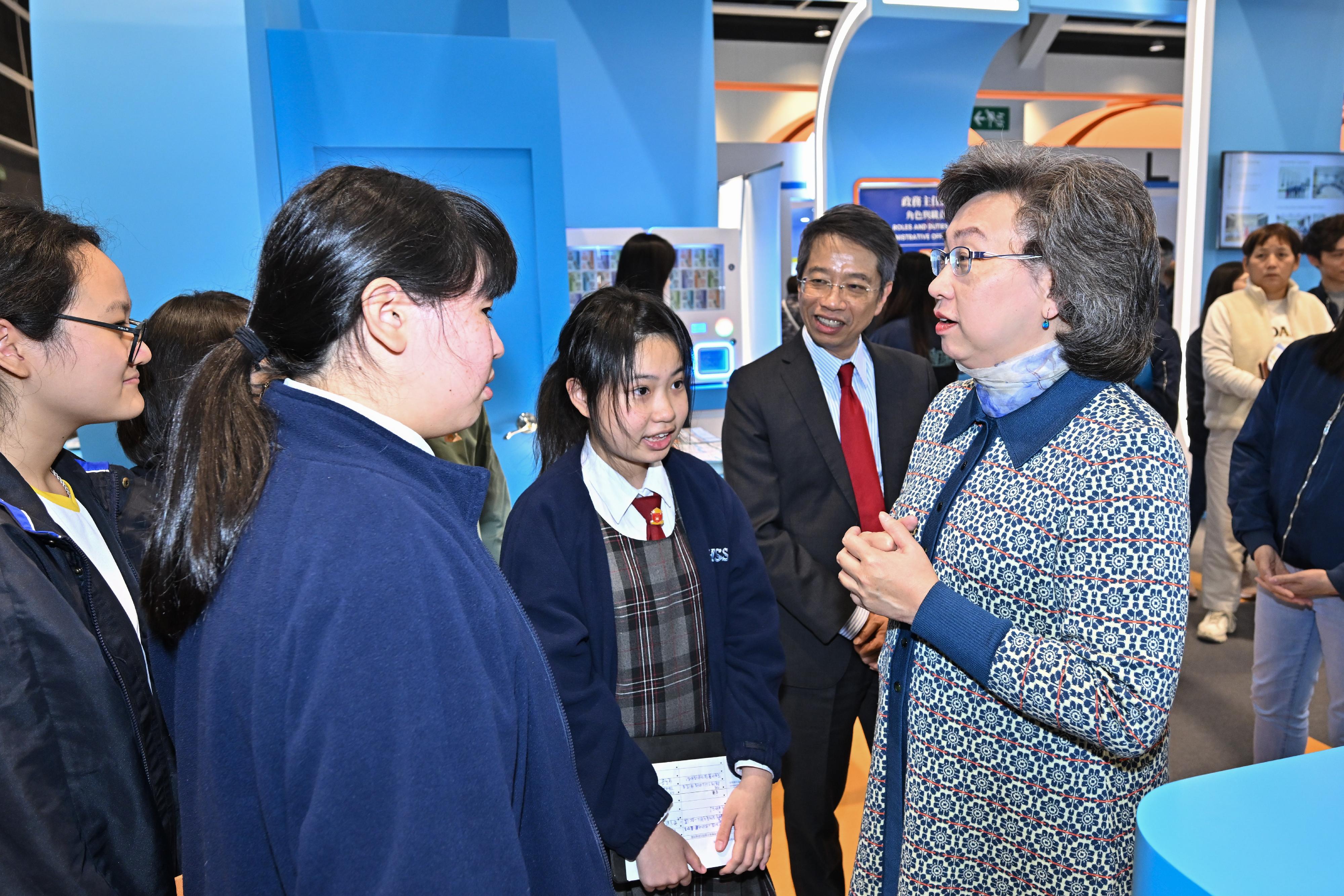 The Civil Service Bureau (CSB) has curated an exhibition area at the Education & Careers Expo 2025 from today (January 16) for four consecutive days to introduce the work of over 50 government grades and provide the public with information on civil service recruitment to enhance job seekers' understanding of government jobs. Photo shows the Secretary for the Civil Service, Mrs Ingrid Yeung (first right), talking with secondary students visiting the CSB's booth. Looking on is the Permanent Secretary for the Civil Service, Mr Clement Leung (second right).