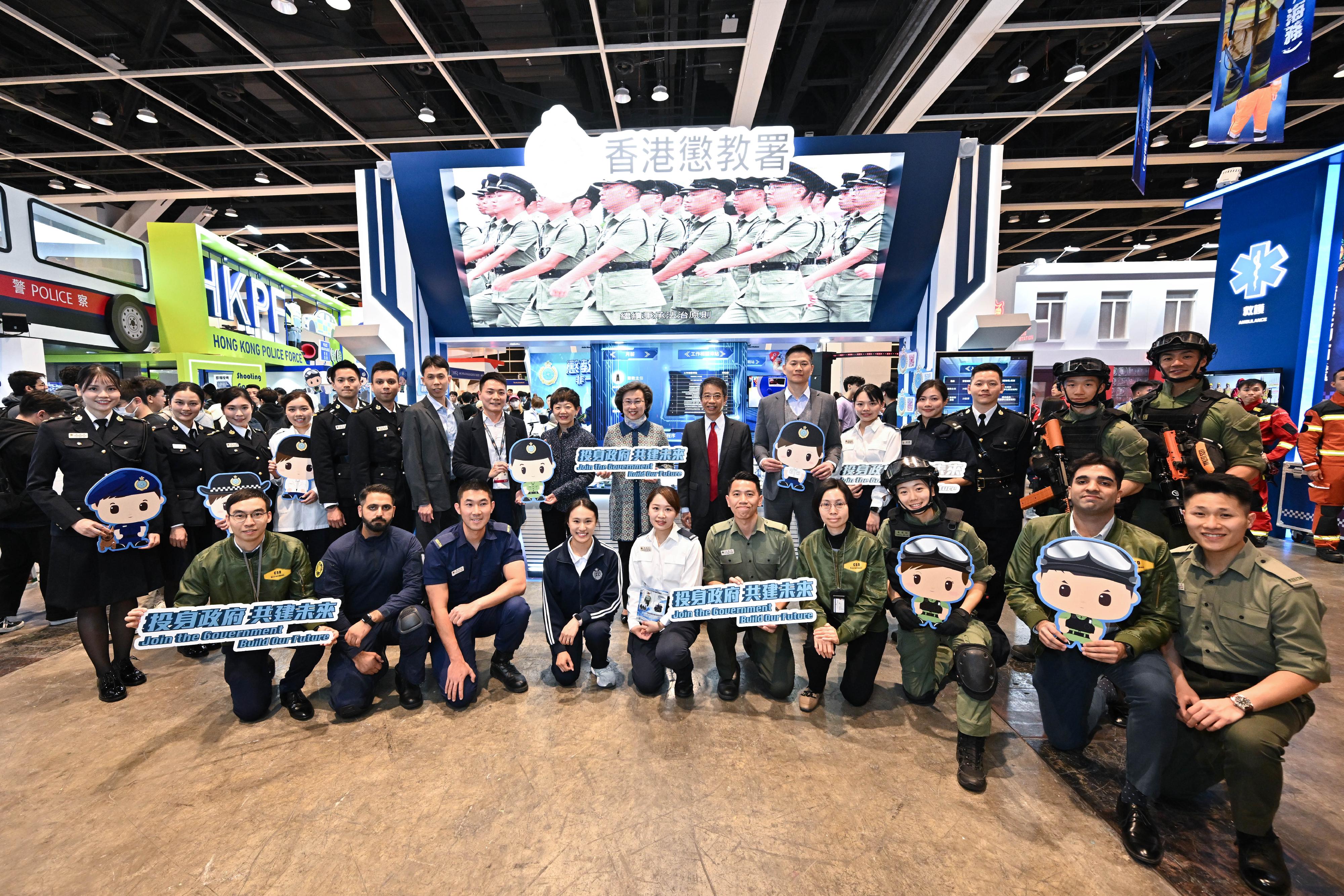 The Civil Service Bureau has curated an exhibition area at the Education & Careers Expo 2025 from today (January 16) for four consecutive days to introduce the work of over 50 government grades and provide the public with information on civil service recruitment to enhance job seekers' understanding of government jobs. The Secretary for the Civil Service, Mrs Ingrid Yeung (back row, eighth right); and the Permanent Secretary for the Civil Service, Mr Clement Leung (back row, seventh right), are pictured with the officers of the Correctional Services Department at the department's booth.