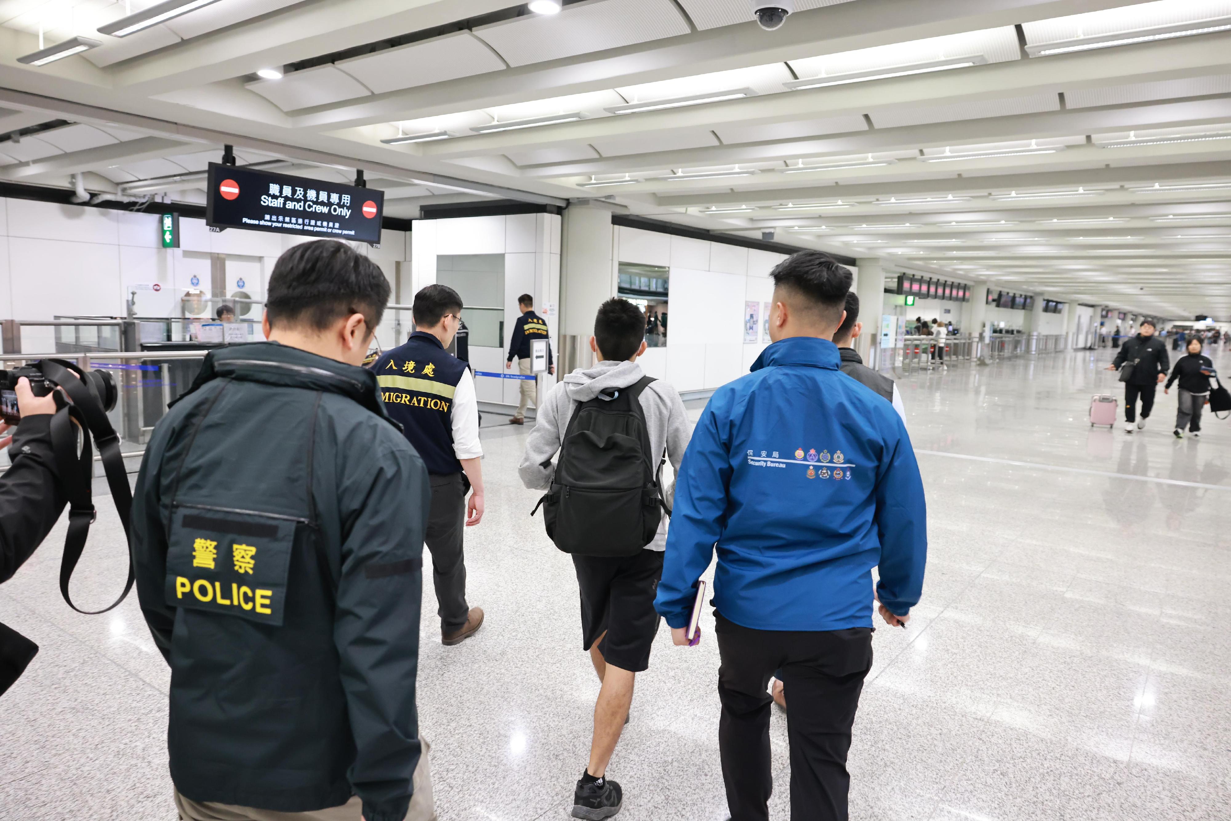 今日（一月十六日）一名求助港人安全抵達香港國際機場，圖示保安局、香港警務處和入境事務處人員在場協助。