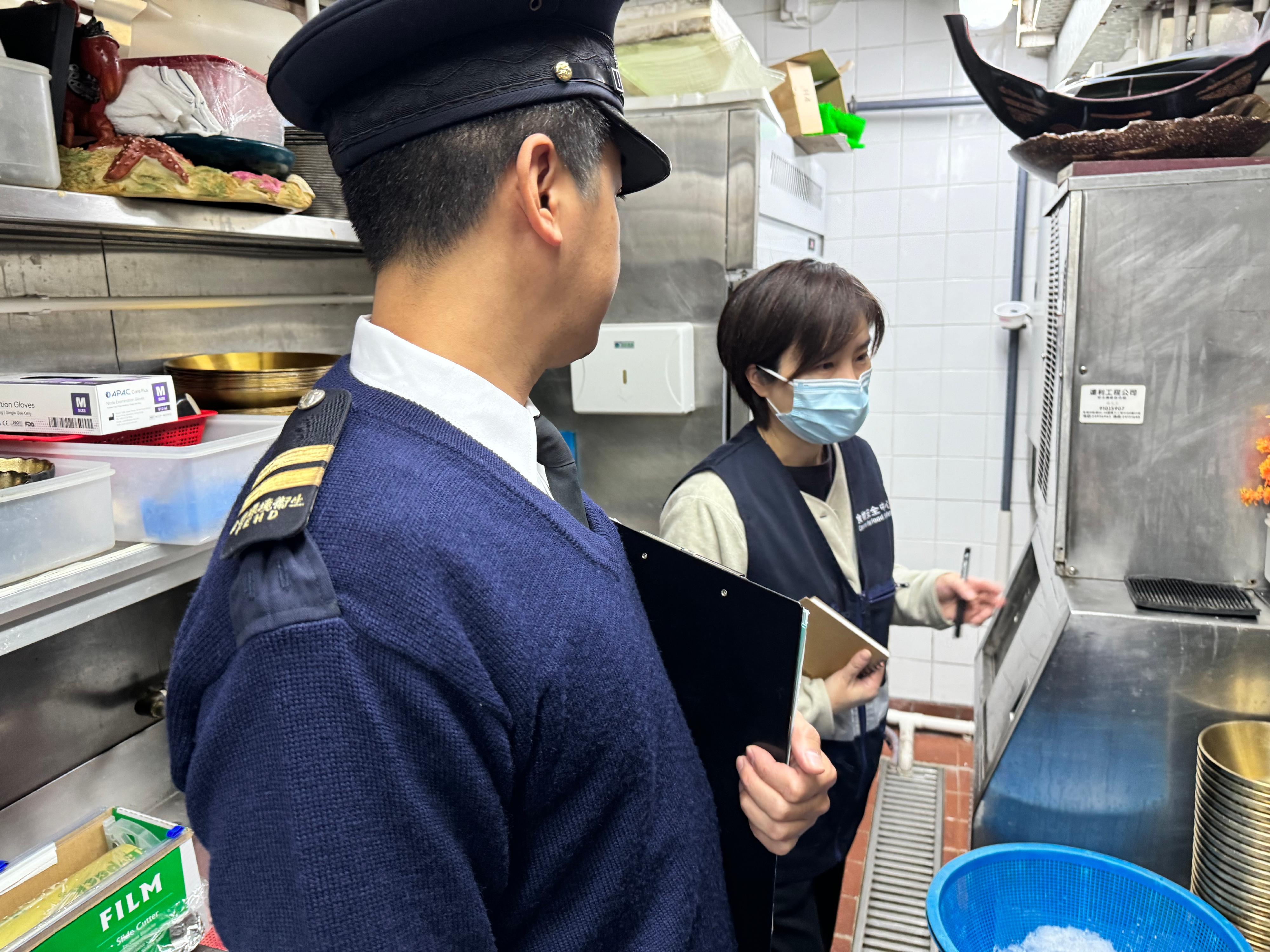 With the Lunar New Year approaching, the Food and Environmental Hygiene Department (FEHD) has stepped up inspections of food premises to protect food safety during the festive season. Photo shows officers of the Centre for Food Safety and the Environmental Hygiene Branch of the FEHD inspecting food premises.