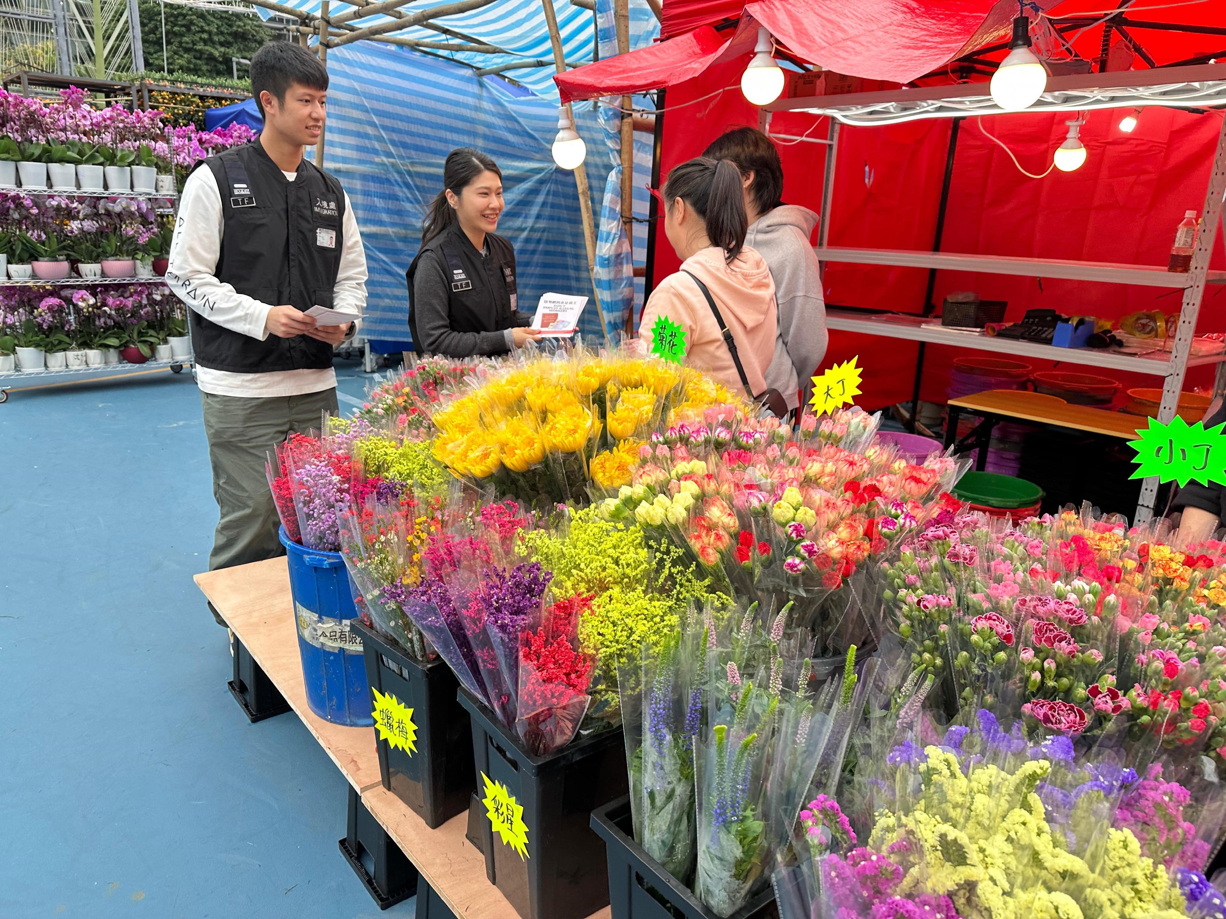 The Immigration Department (ImmD) mounted a series of territory-wide anti-illegal worker operations codenamed "Twilight", joint operations with the Hong Kong Police Force codenamed "Champion" and "Windsand", and joint operations with the Labour Department to combat illegal employment activities at Lunar New Year fairs for four consecutive days from January 20 to yesterday (January 24). Photo shows Immigration Task Force officers distributing "Don't Employ Illegal Workers" leaflets to Lunar New Year fair stall keepers.