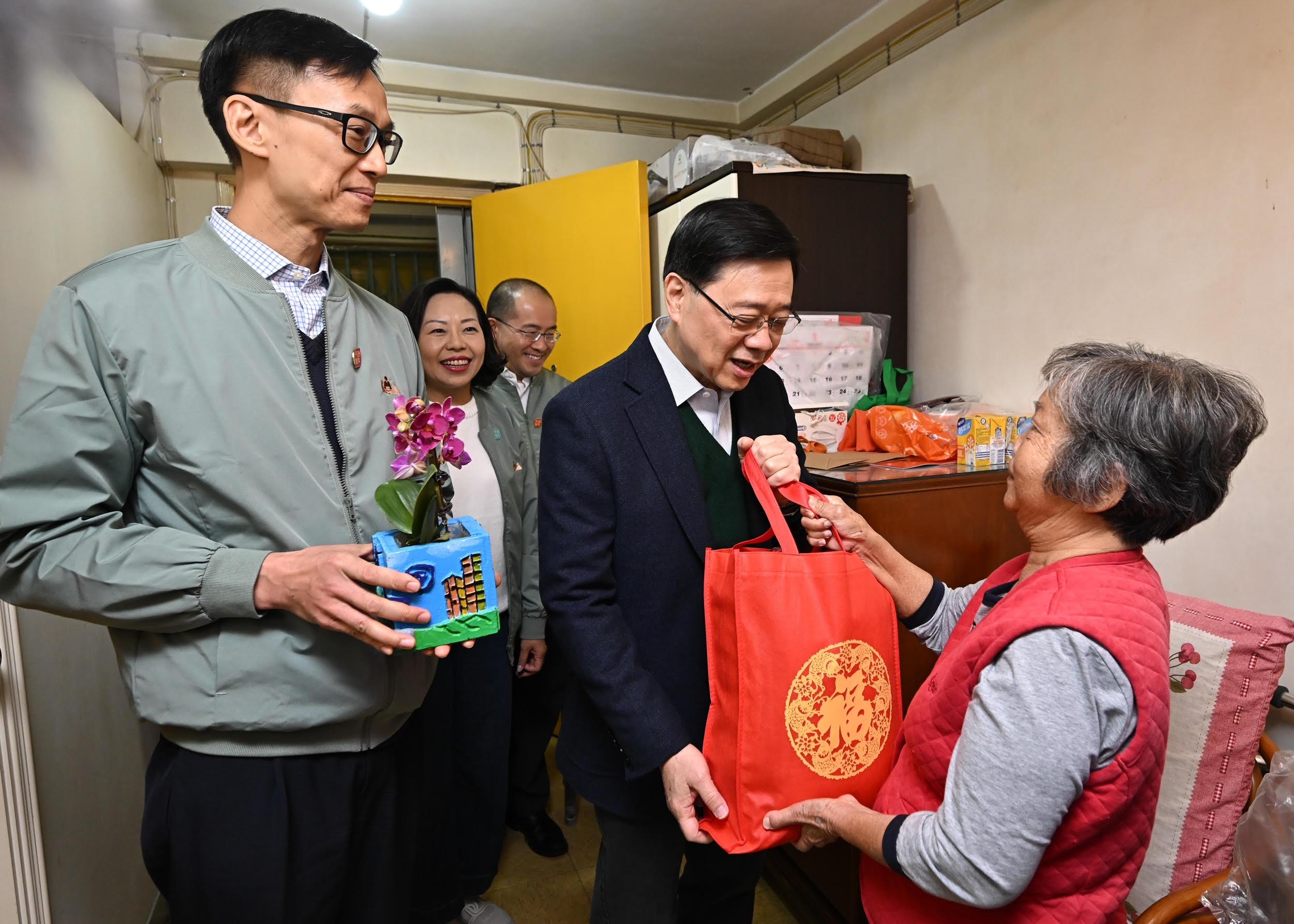 The Chief Executive, Mr John Lee, visited Ho Man Tin today (January 25). Photo shows Mr Lee (second right), accompanied by the Secretary for Home and Youth Affairs, Miss Alice Mak (second left), and the District Officer (Kowloon City), Mr Ivanhoe Chang (first left), visiting a singleton elderly person living in Oi Man Estate, Kowloon City District, and presenting to her a blessing bag.