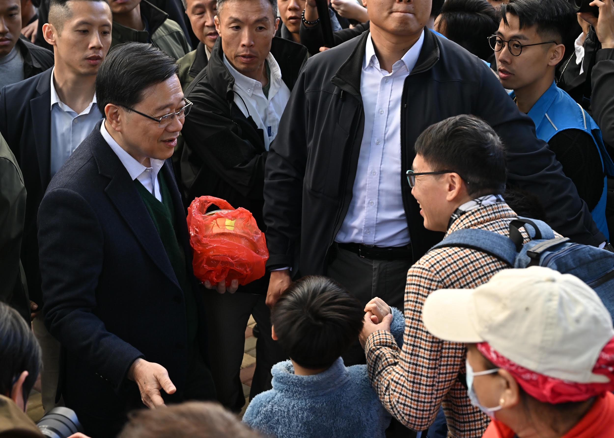The Chief Executive, Mr John Lee, visited Ho Man Tin today (January 25). Photo shows Mr Lee (second left) visiting Oi Man Estate, Kowloon City District, and interacting with residents of the district.