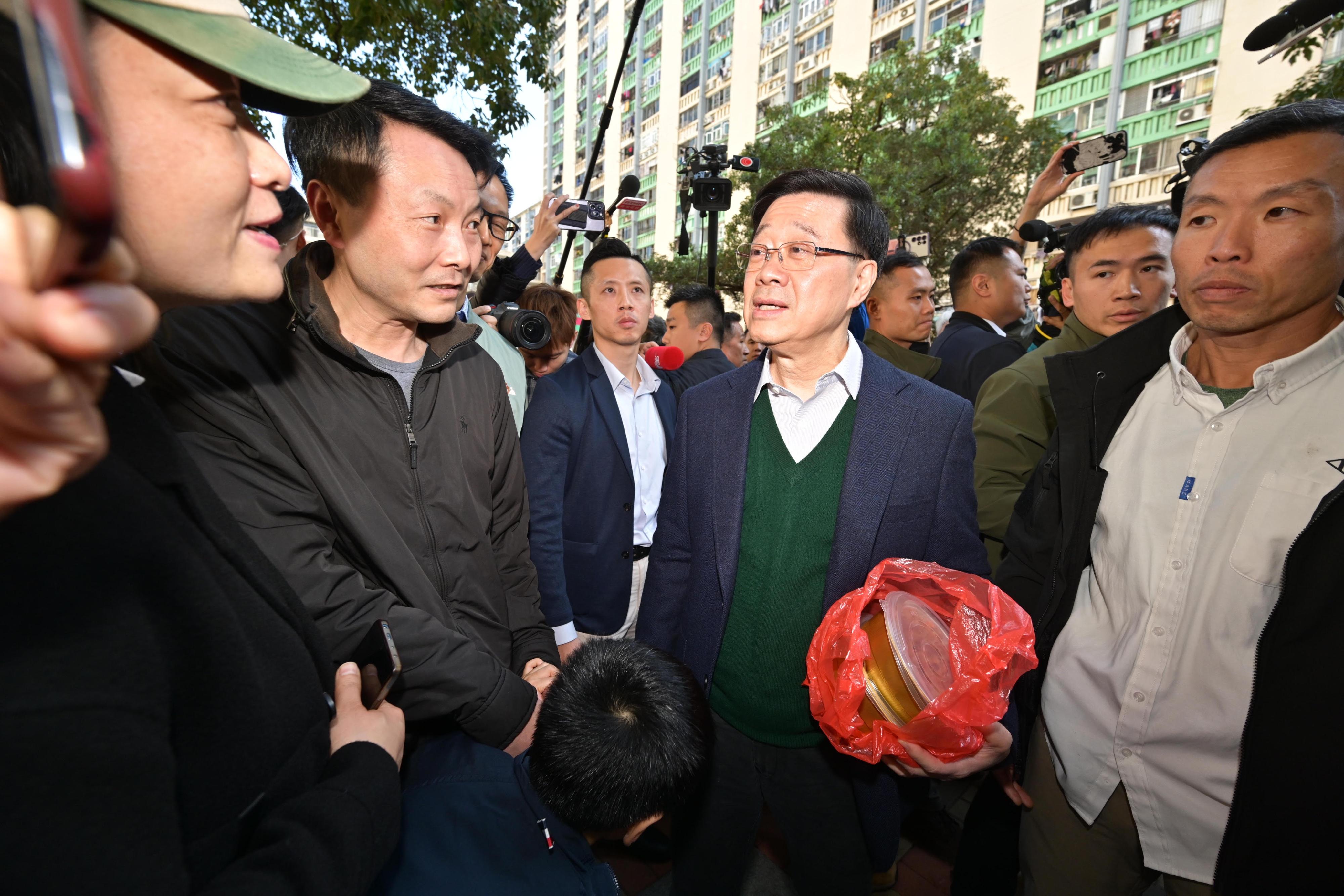 The Chief Executive, Mr John Lee, visited Ho Man Tin and Hung Hom today (January 25). Photo shows Mr Lee (third right) visiting Oi Man Estate, Kowloon City District, and interacting with residents of the district.