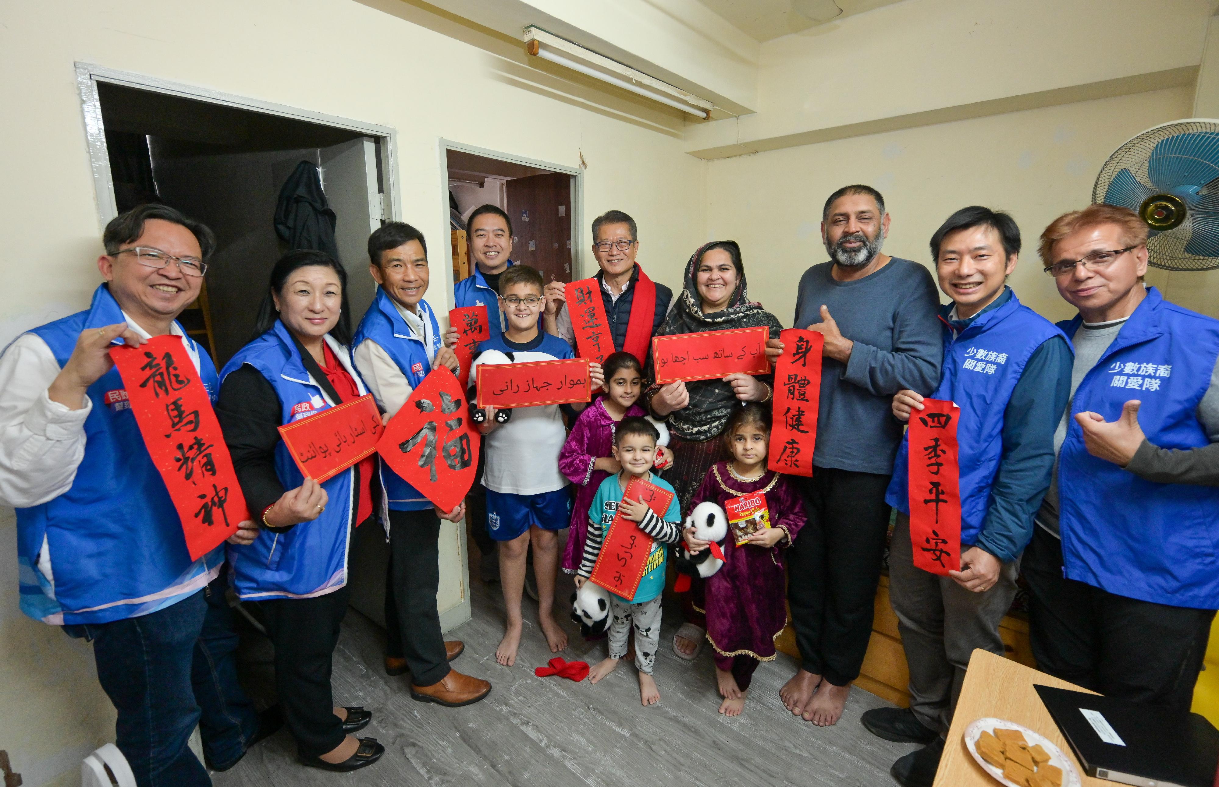 The Financial Secretary, Mr Paul Chan (sixth left), accompanied by the District Officer (Yau Tsim Mong), Mr Edward Yu (fourth left), together with Yau Tsim Mong District Council members and representatives from the District Services and Community Care Team (Yau Tsim Mong) and the Ethnic Minority Care Team, visited an ethnic minority family living on Reclamation Street today (January 25).