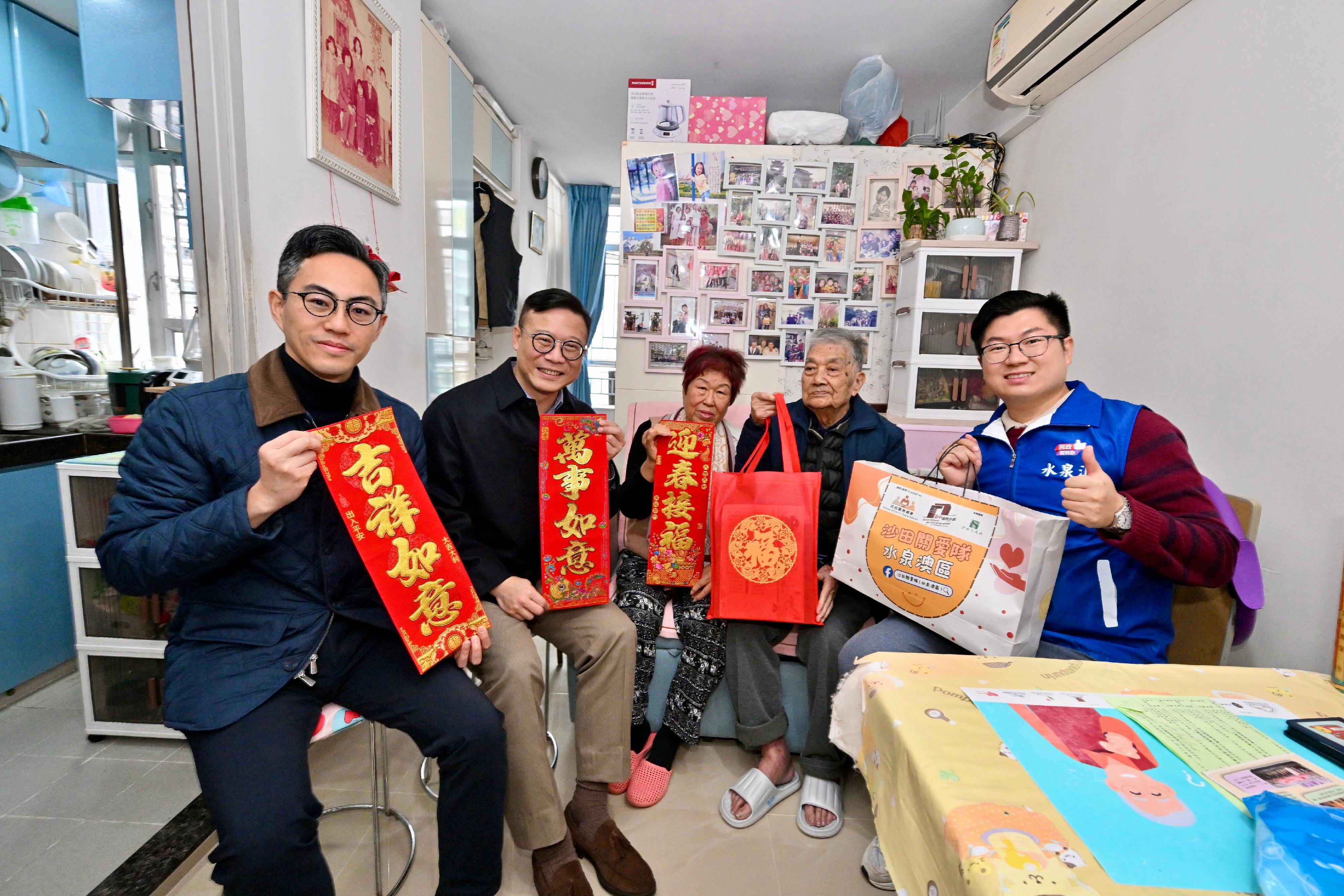The Deputy Secretary for Justice, Dr Cheung Kwok-kwan (second left), accompanied by the District Officer (Sha Tin), Mr Frederick Yu (first left), together with a representative from the District Services and Community Care Team (Sha Tin), visited a grassroots family living in Shui Chuen O Estate, Sha Tin,  to extend care and blessings today (January 26).