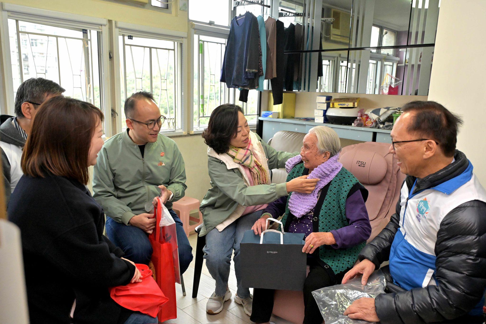 The Secretary for Home and Youth Affairs, Miss Alice Mak (third right), accompanied by the District Officer (Tuen Mun), Mr Michael Kwan (fourth right), and Tuen Mun District Council members and representatives from the District Services and Community Care Team (Tuen Mun) visit an elderly singleton living in Tin King Estate, today (January 26).