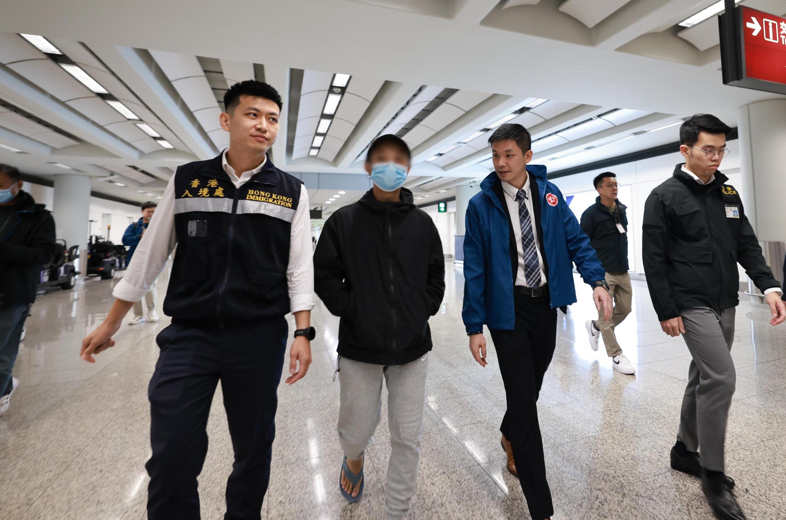 ​一名在緬甸被禁錮從事非法工作並於日前獲救的香港居民（左二），昨日（一月二十七日）晚上在專責小組陪同下順利由泰國返回香港。圖示保安局、香港警務處和入境事務處人員在場協助。
