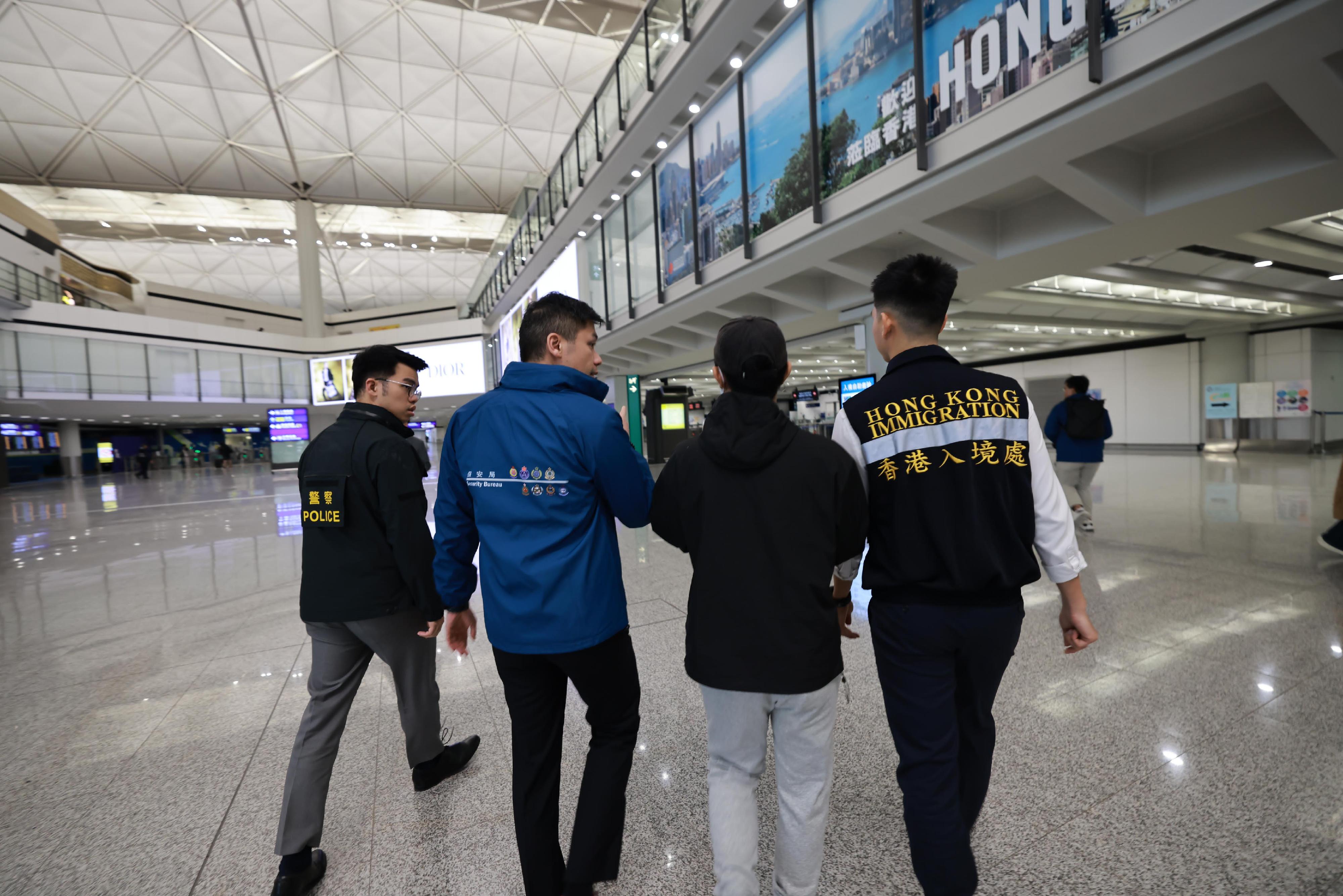 A Hong Kong resident, who had been detained for illegal work in Myanmar and was recently rescued, has smoothly returned to Hong Kong from Thailand (second right) last night (January 27) under the accompany of members of the dedicated task force. Photo shows staff of the Security Bureau, the Hong Kong Police Force and the Immigration Department providing assistance on-site.