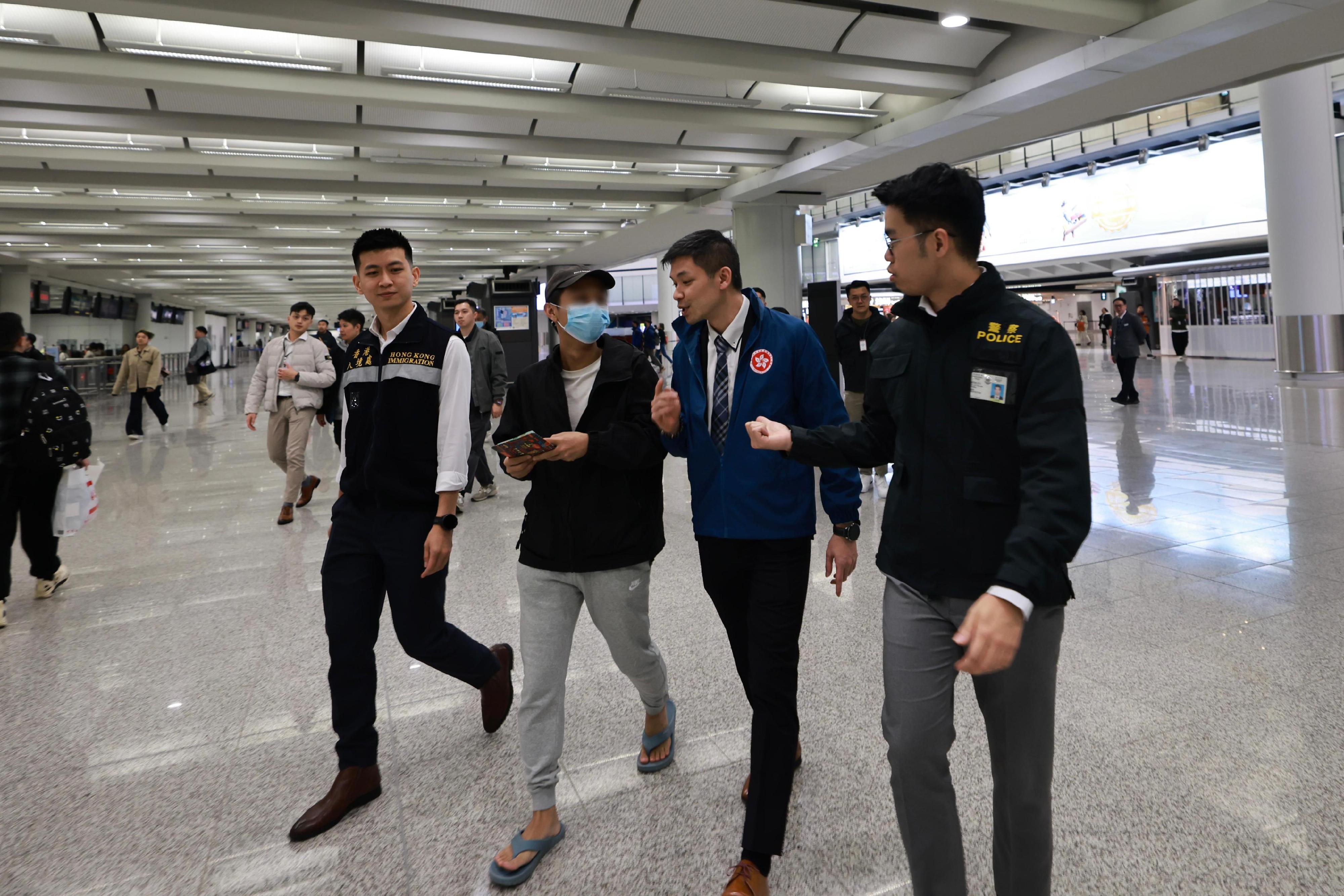 A Hong Kong resident, who had been detained for illegal work in Myanmar and was recently rescued, has smoothly returned to Hong Kong from Thailand (second left) last night (January 27) under the accompany of members of the dedicated task force. Photo shows staff of the Security Bureau, the Hong Kong Police Force and the Immigration Department providing assistance on-site.