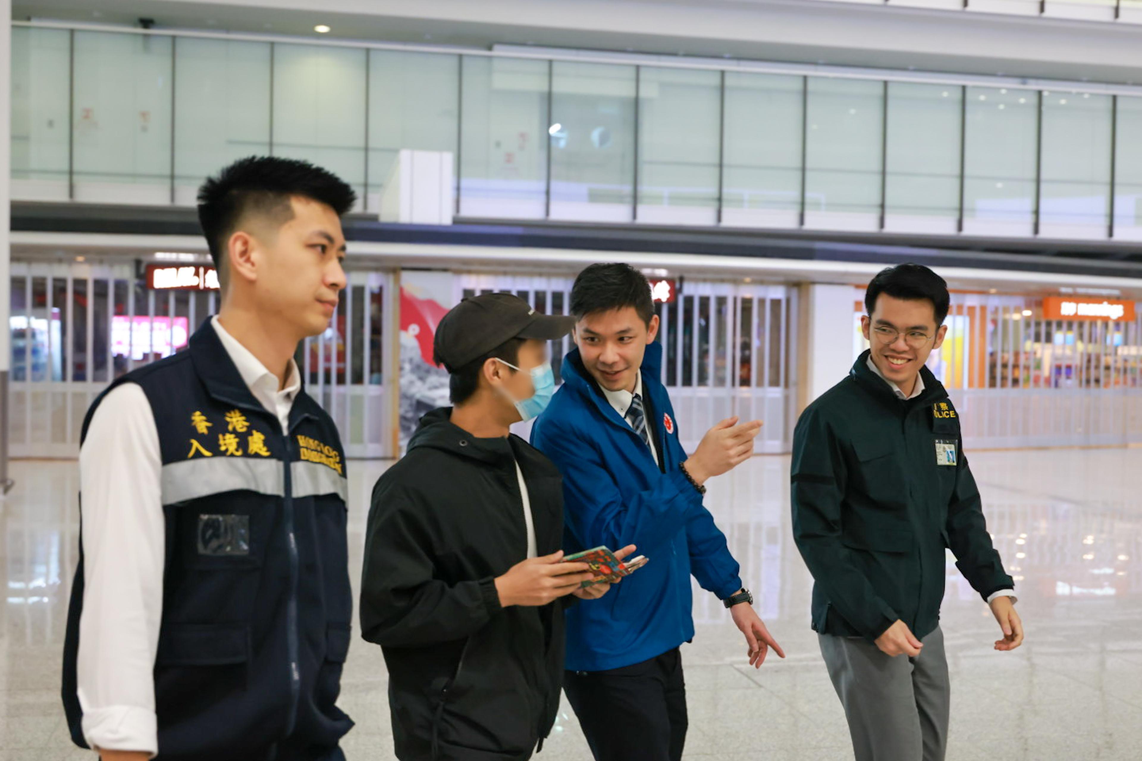 A Hong Kong resident, who had been detained for illegal work in Myanmar and was recently rescued, has smoothly returned to Hong Kong from Thailand (second left) last night (January 27) under the accompany of members of the dedicated task force. Photo shows staff of the Security Bureau, the Hong Kong Police Force and the Immigration Department providing assistance on-site.