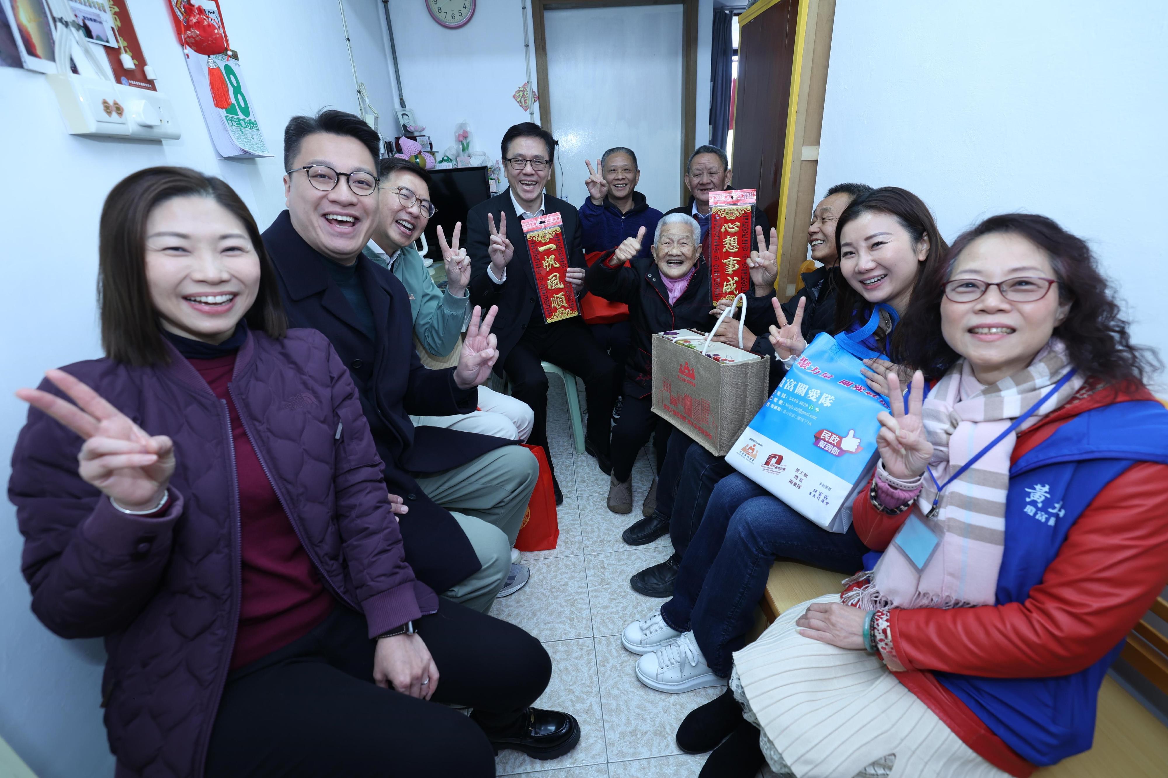 創新科技及工業局局長孫東教授（左四）今日（一月二十八日）在黃大仙民政事務專員胡鉅華（左三）陪同下，聯同黃大仙區區議員和黃大仙區關愛隊代表，探訪居於富山邨的長者家庭，在農曆新年前送上關愛和祝福。