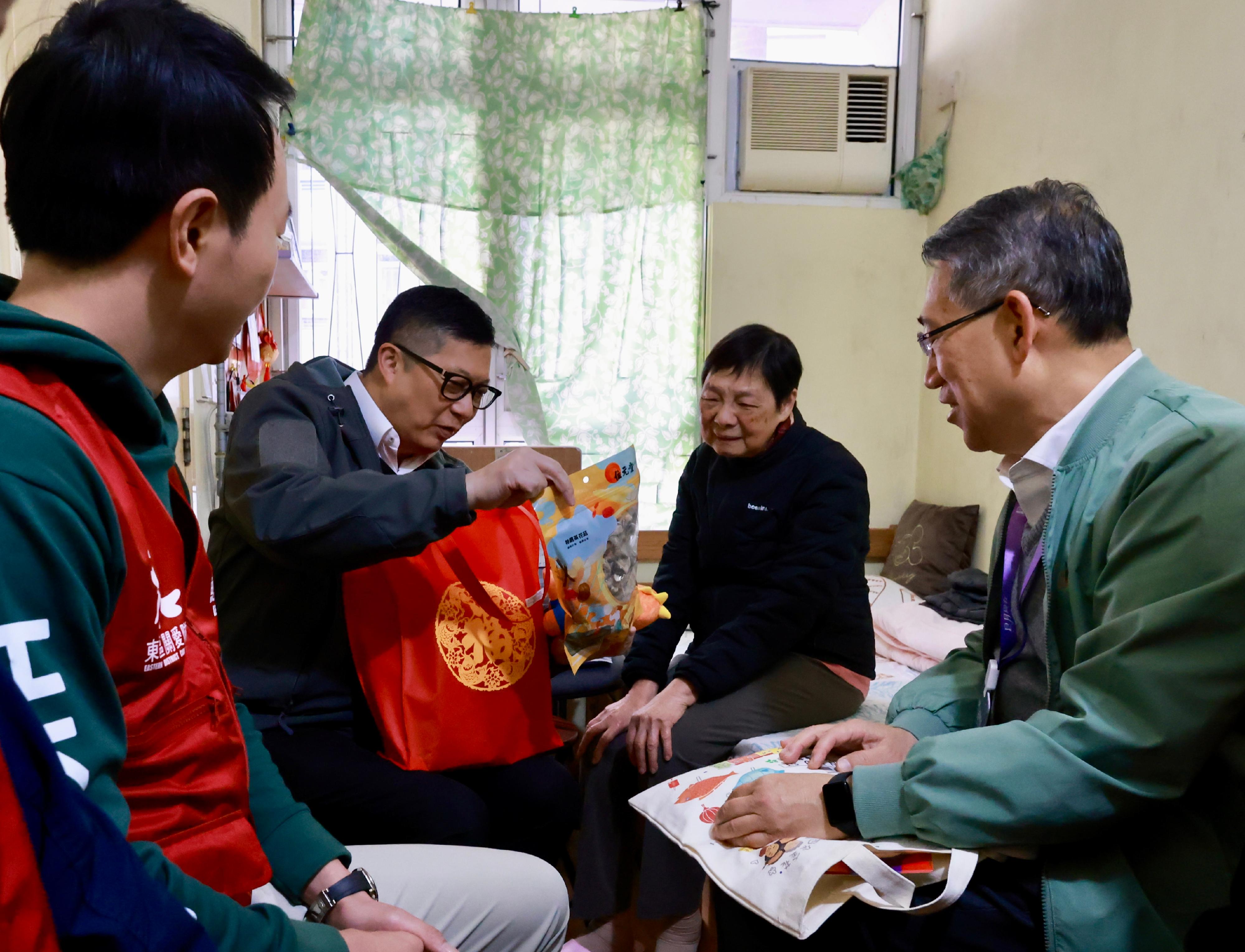 保安局局長鄧炳強（左二）今日（一月二十八日）在東區民政事務專員陳尚文（右一）陪同下，聯同東區區議員和東區關愛隊代表探訪居於康東邨的長者戶。