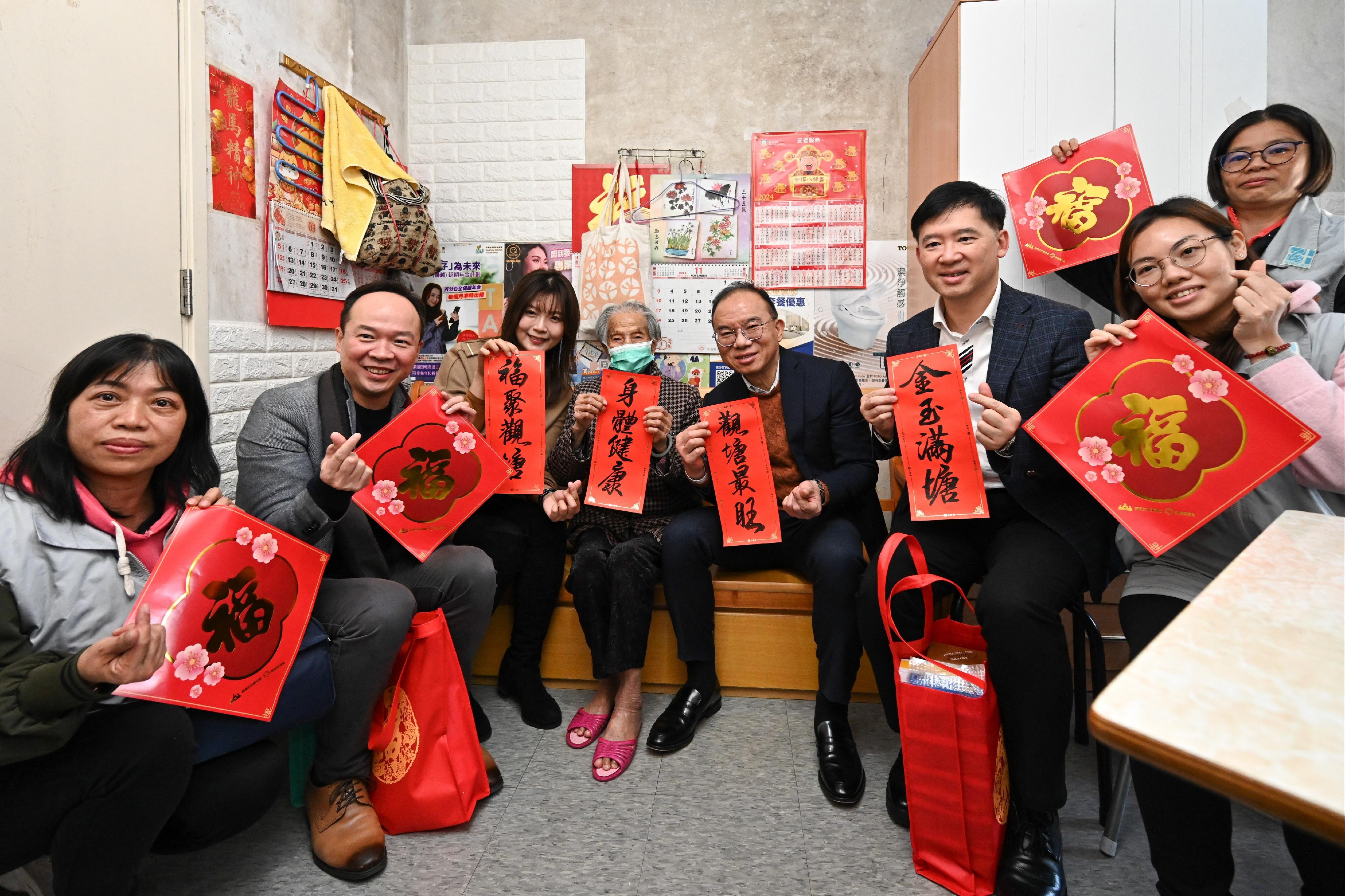 The Secretary for Constitutional and Mainland Affairs, Mr Erick Tsang Kwok-wai (fourth right), accompanied by the Under Secretary for Constitutional and Mainland Affairs, Mr Clement Woo (third right), and the Acting District Officer (Kwun Tong), Ms Regina Chan (third left), together with Kwun Tong District Council members and representatives from the District Services and Community Care Team (Kwun Tong), visited elderly singletons living in Lam Tin Estate to chat with them and celebrate the festive joy of the Chinese New Year together.