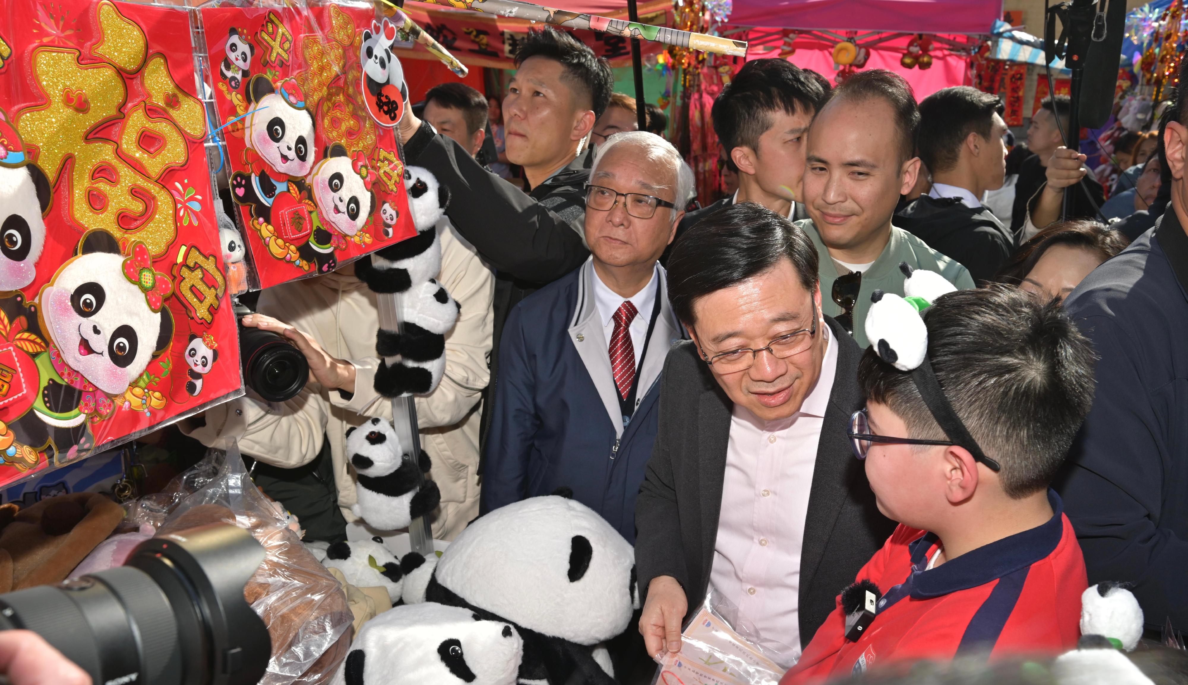 行政長官李家超今日（一月二十八日）到訪屯門天后廟廣場年宵市場。圖示李家超（第一排右二）與學生交流。旁為環境及生態局局長謝展寰（第二排左一）。

