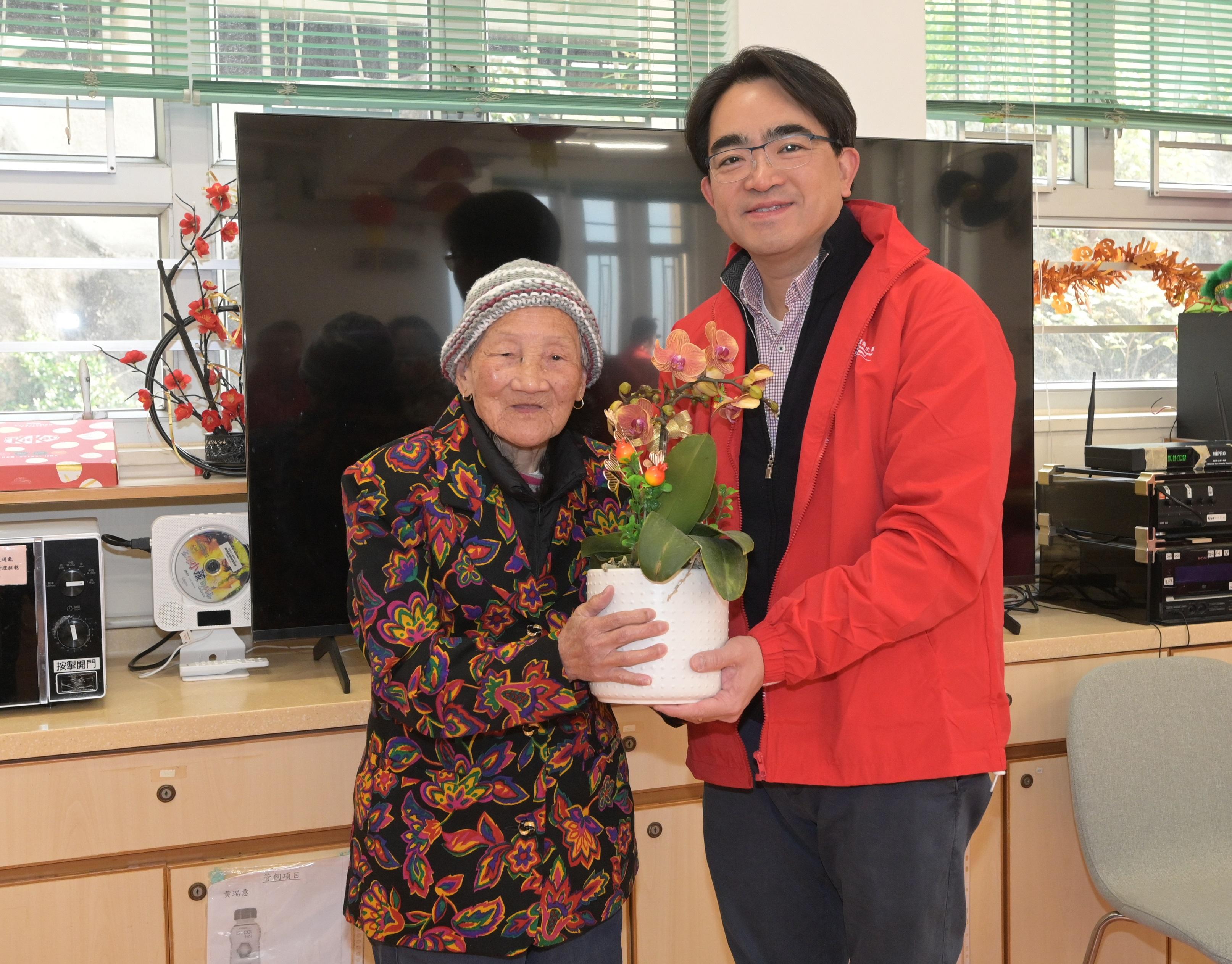 二○二五年農曆年宵市場今日（一月二十九日）年初一清晨七時圓滿結束。食物環境衞生署（食環署）員工組成的義工隊協助部門把花檔檔主自願送贈未售出的花卉和盆栽轉贈予安老院／殘疾人士院舍和公立醫院。圖示食環署署長吳文傑將年花轉贈予一位安老院長者。