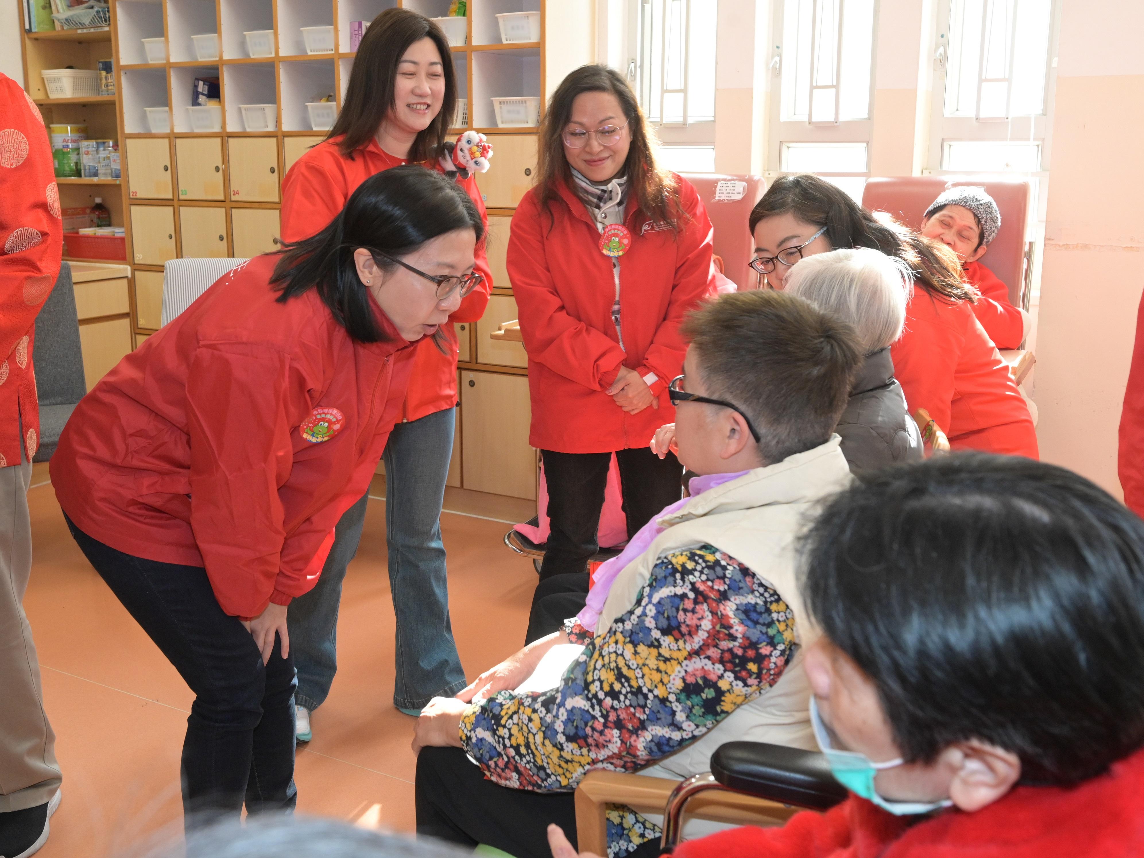 The 2025 Lunar New Year (LNY) fairs concluded successfully at 7am today (January 29). Volunteer teams made up of the Food and Environmental Hygiene Department staff assisted the department to deliver unsold pots of flowers and plants donated by LNY fair licensees to elderly home/residential care homes for person with disabilities and public hospitals. Photo shows volunteers extending New Year greetings to elderly persons at a residential care home for the elderly.